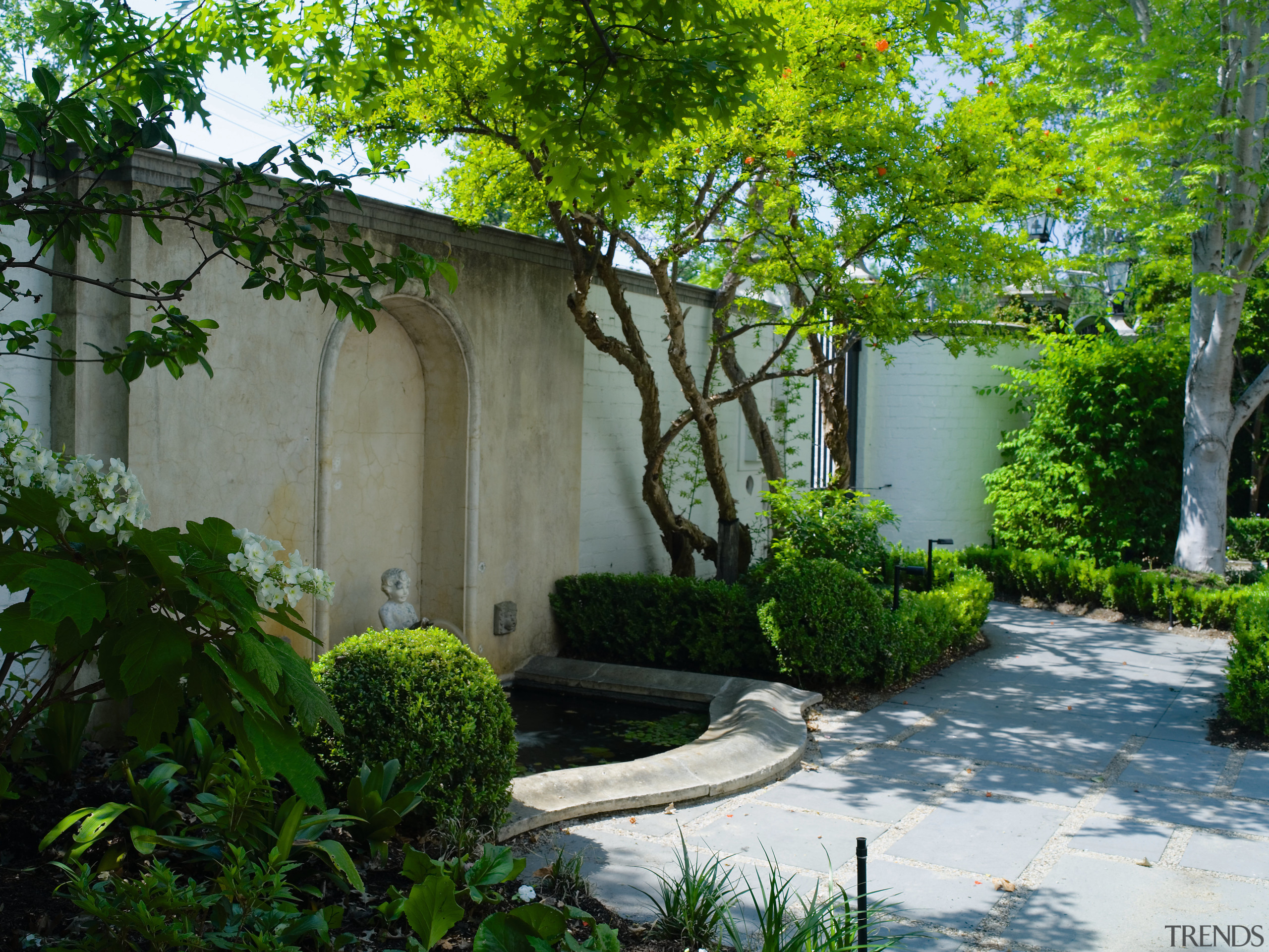 An exterior view of the house and its backyard, cottage, courtyard, estate, garden, grass, home, house, landscape, landscaping, leaf, outdoor structure, plant, property, real estate, shrub, tree, vegetation, wall, yard, green