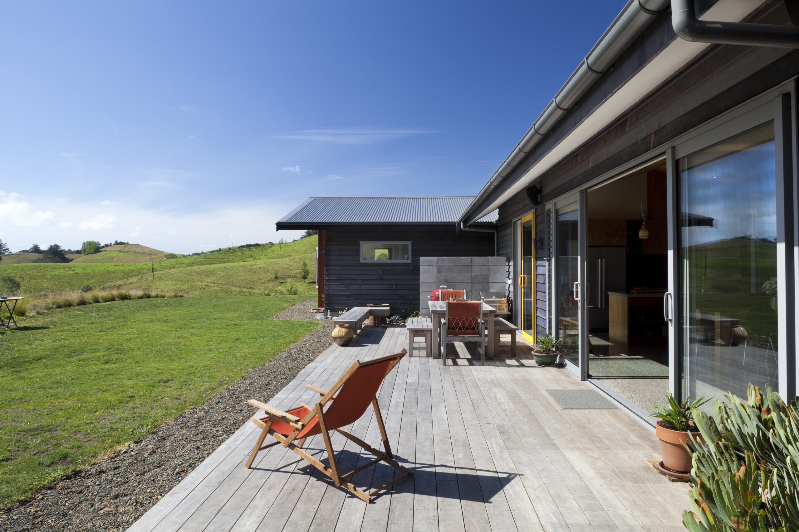 View of wooden patio with view out to architecture, backyard, cottage, estate, home, house, landscape, property, real estate, roof, sky