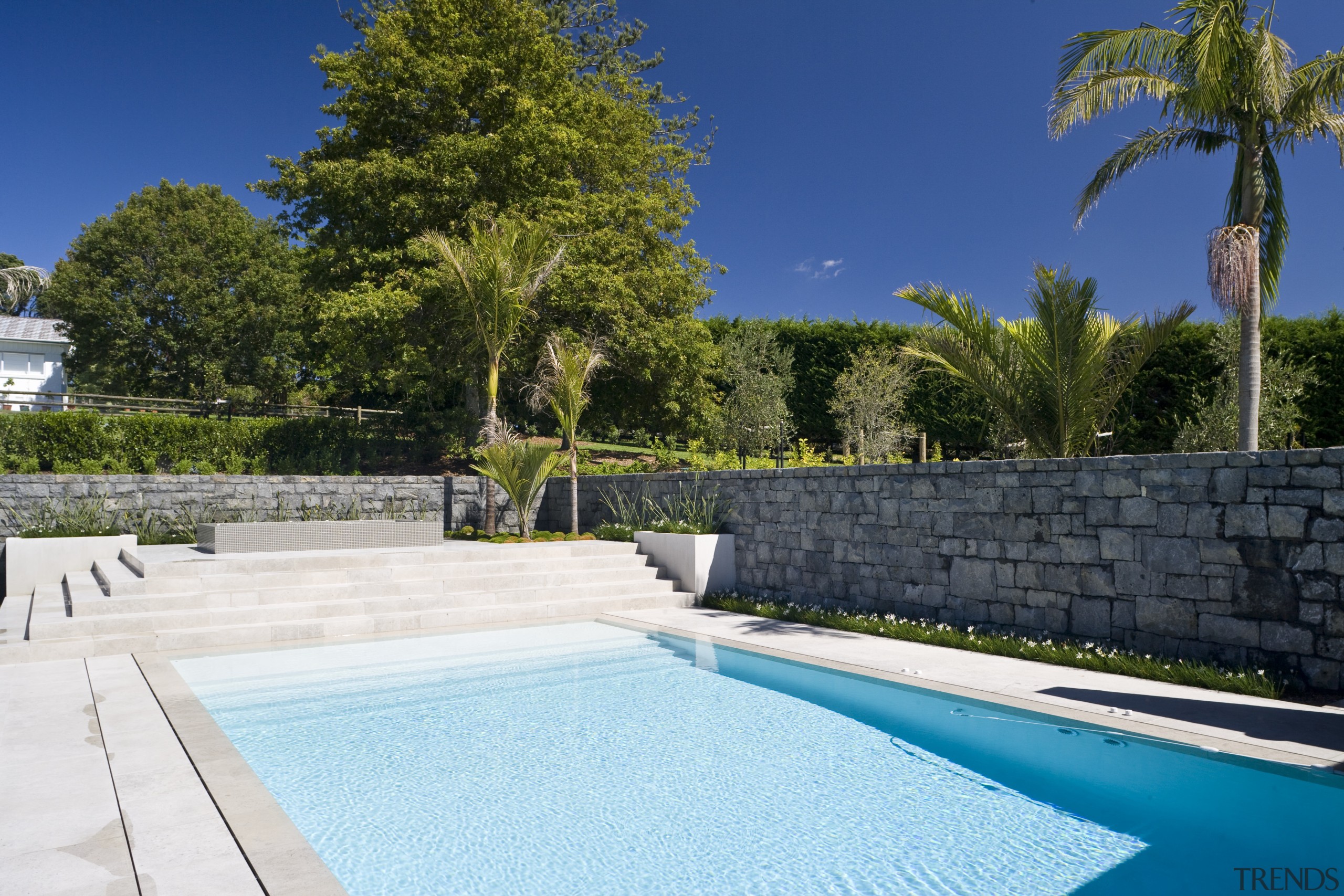 Image of stone walls which have been built backyard, estate, home, house, leisure, property, real estate, resort, sky, swimming pool, villa, water