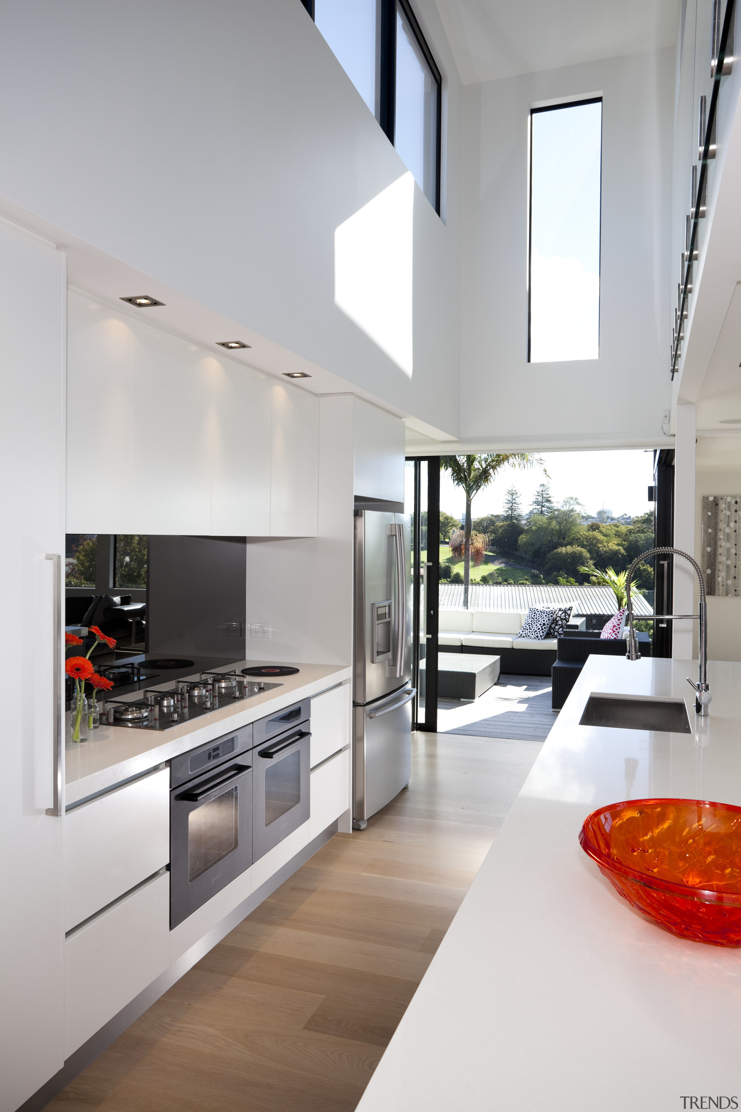 Contemporary kitchen with wooden flooring, white cupboards, white architecture, countertop, house, interior design, kitchen, living room, white, gray