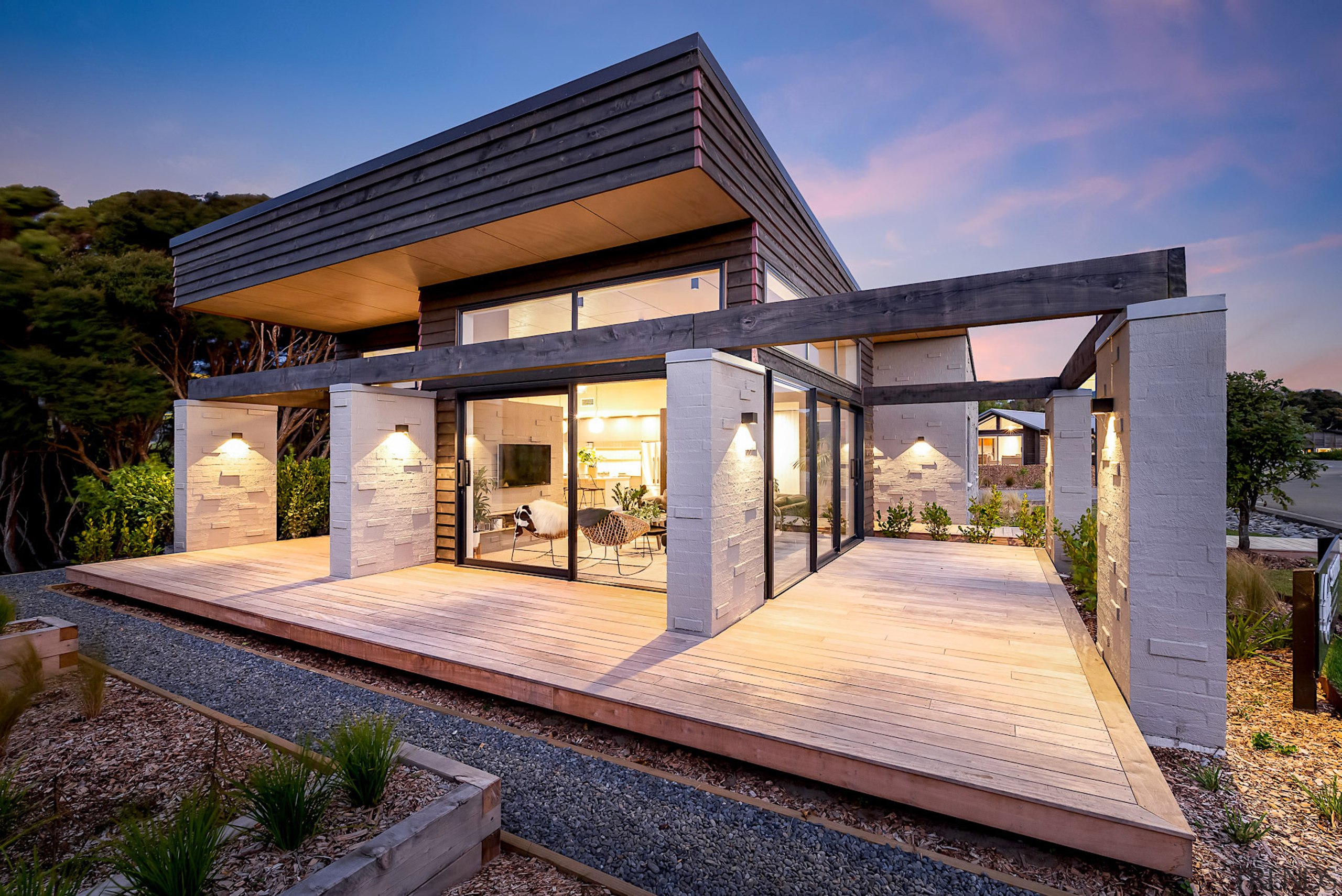 Wood decking surrounds the indoor-outdoor home. 
