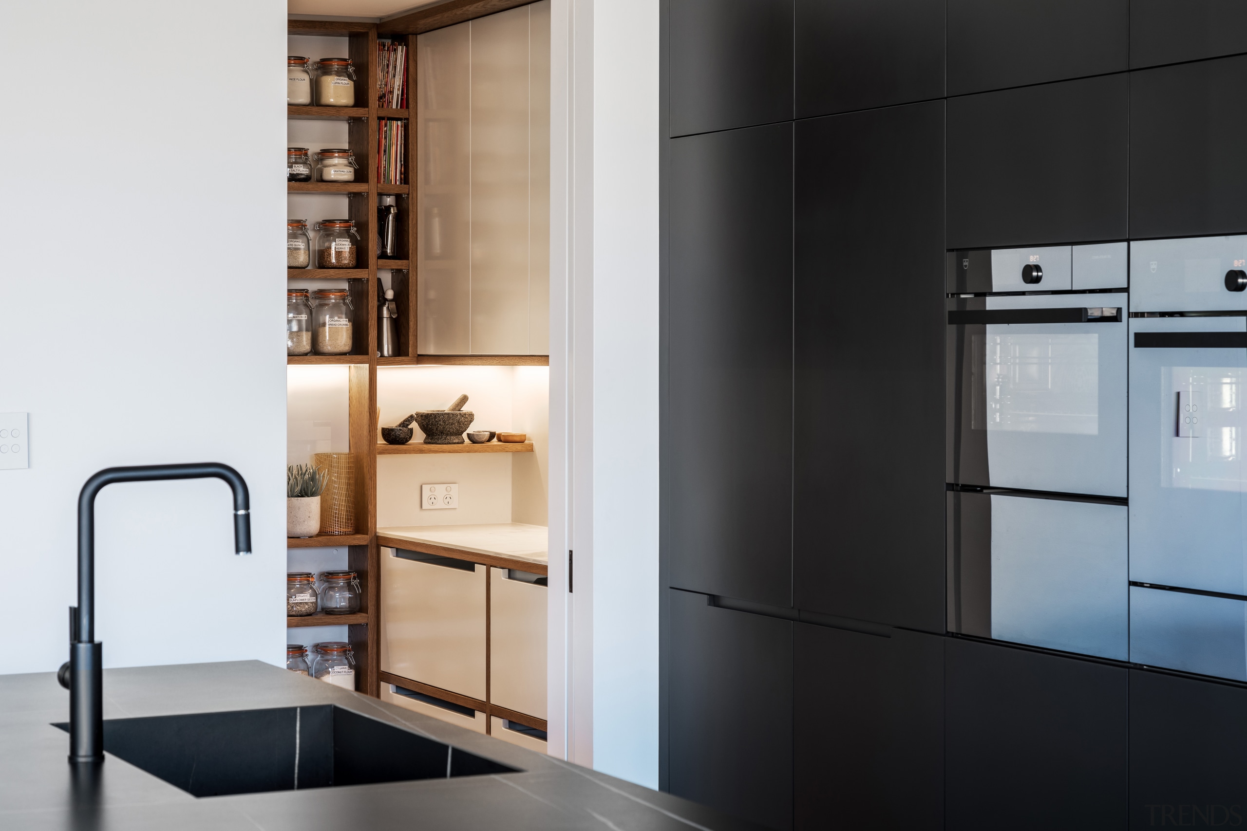 ​​​​​​​A sliding pantry door reveals fitted cabinetry and 