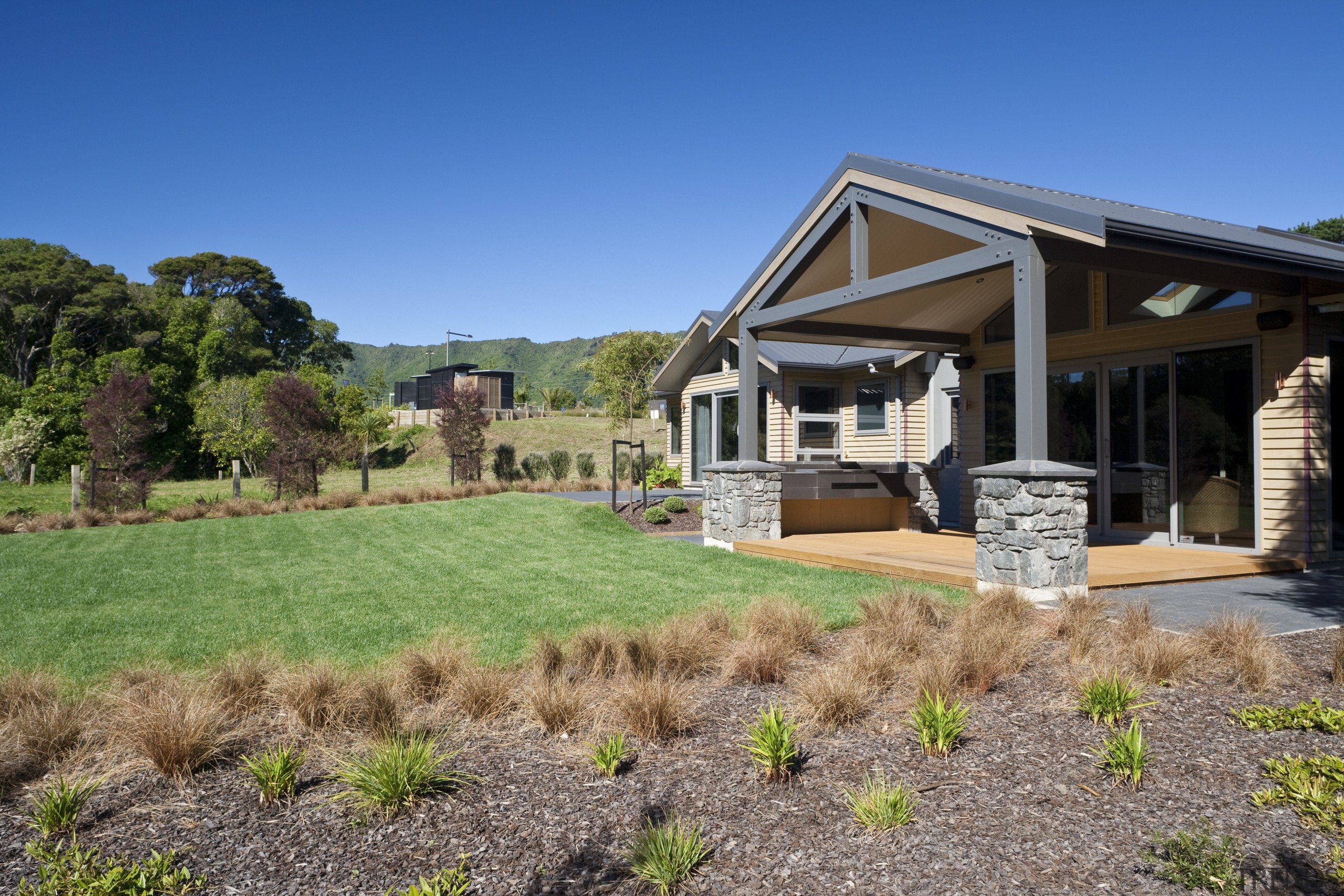 Exterior view of an energy-efficient home and gardens backyard, cottage, estate, facade, farmhouse, grass, home, house, land lot, landscape, landscaping, lawn, property, real estate, residential area, sky, yard