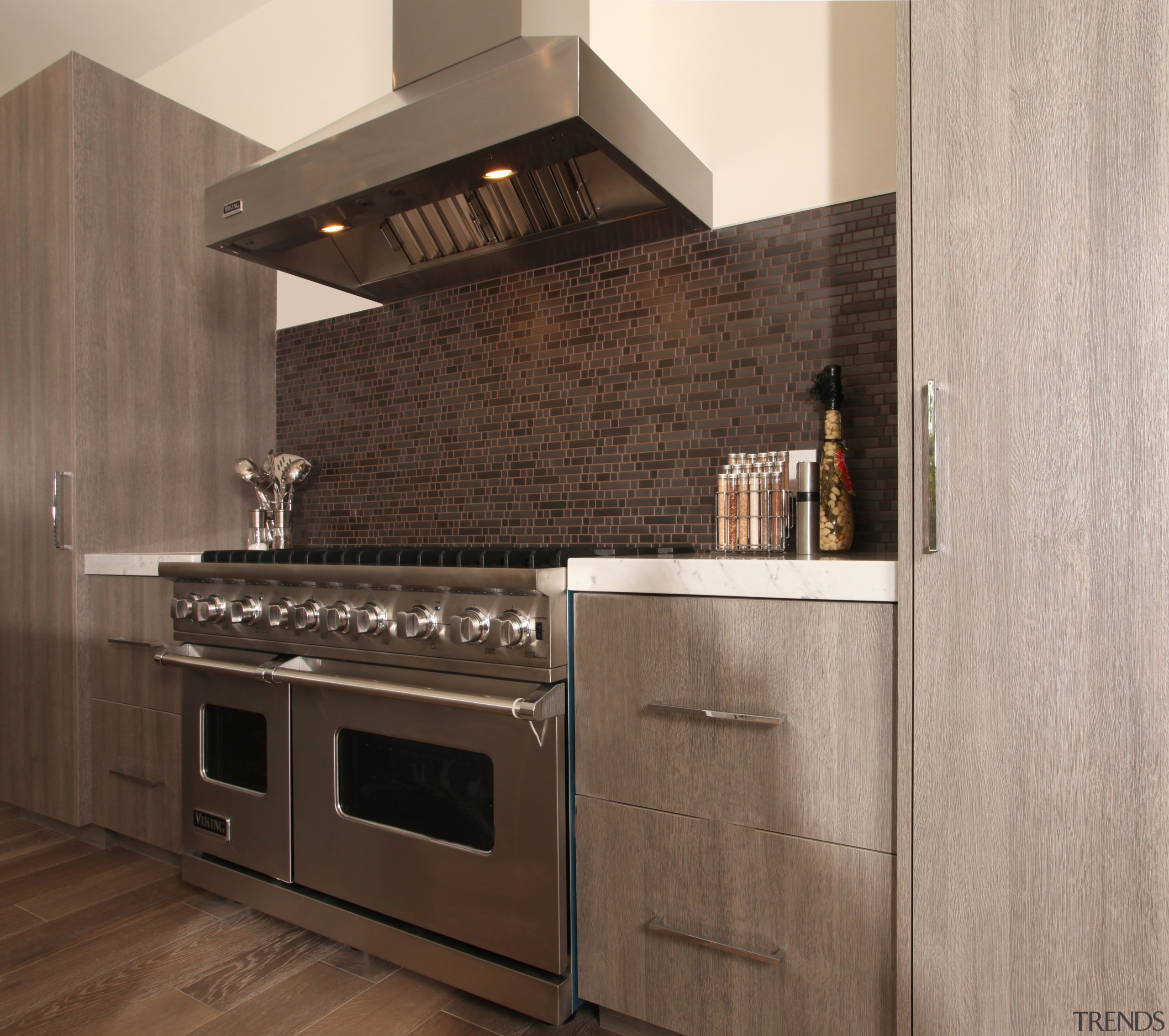 Tall cabinets frame the cooking zone in this cabinetry, countertop, cuisine classique, floor, flooring, hardwood, home appliance, interior design, kitchen, kitchen appliance, kitchen stove, tile, wood flooring, gray, brown, black