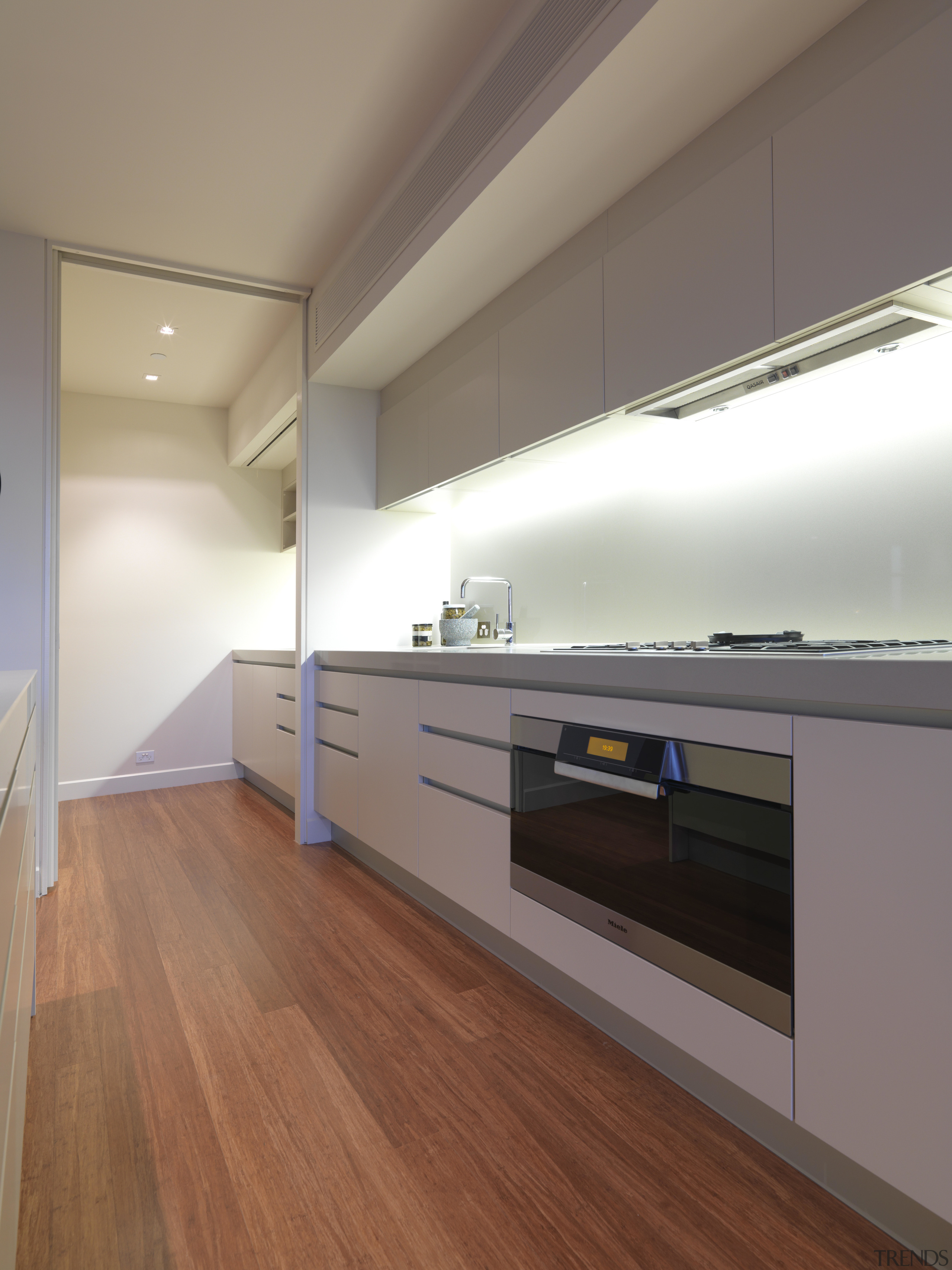 View of the kitchen area of an apartment architecture, cabinetry, countertop, daylighting, floor, flooring, hardwood, interior design, kitchen, laminate flooring, real estate, room, wood, wood flooring, brown, gray