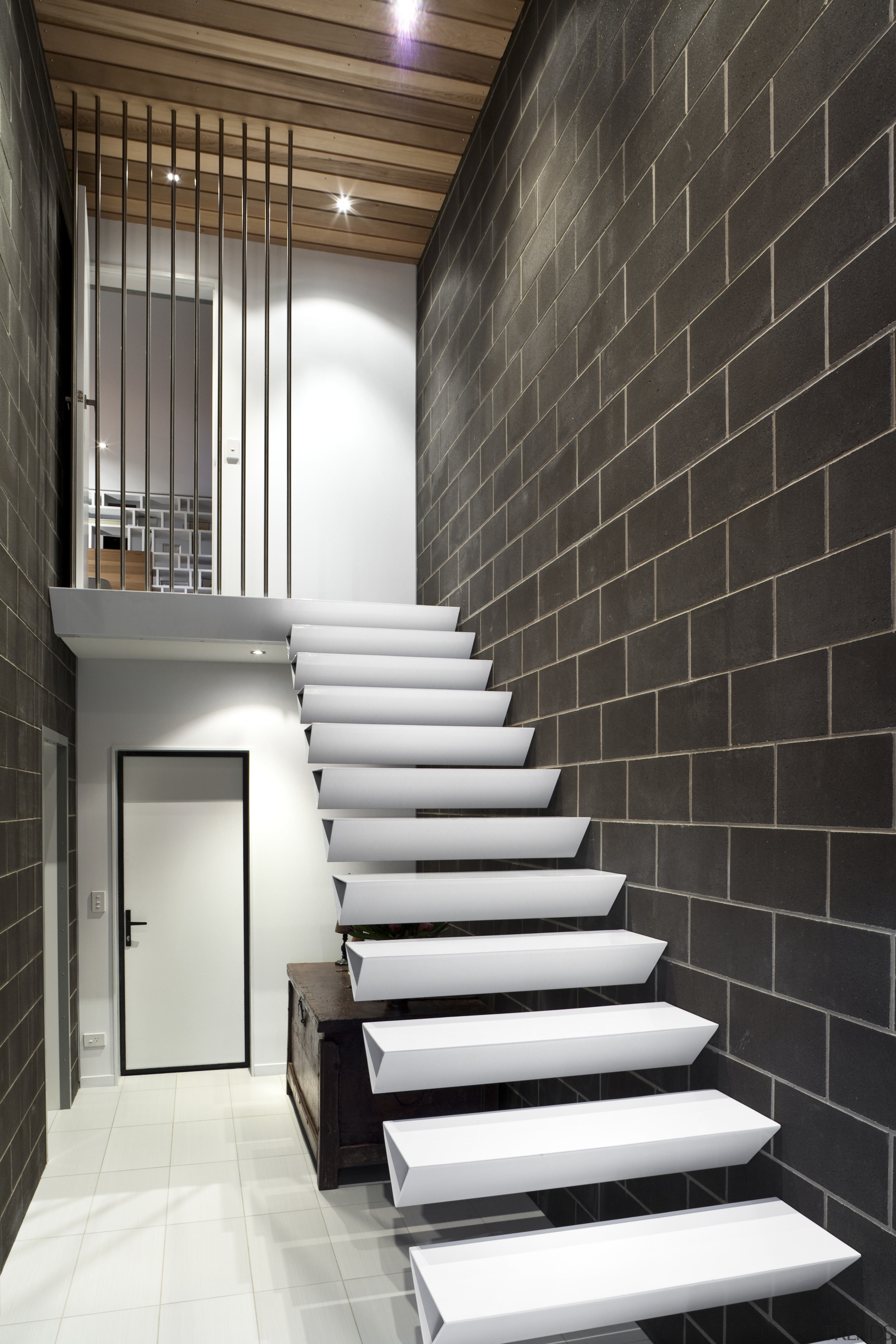 View of cantilevered, triangular-shaped steel stairs, tiled floors, architecture, ceiling, daylighting, floor, flooring, handrail, home, house, interior design, lobby, loft, stairs, wall, black, white