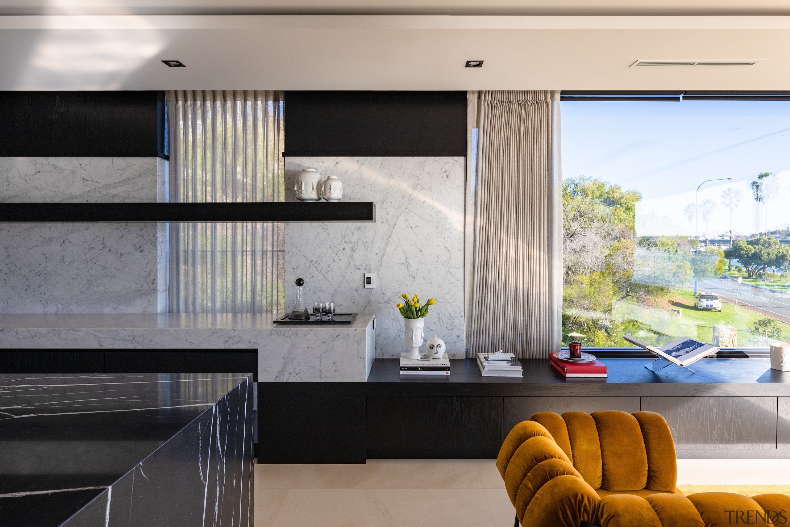 The perimeter bench steps down to storage cabinetry 