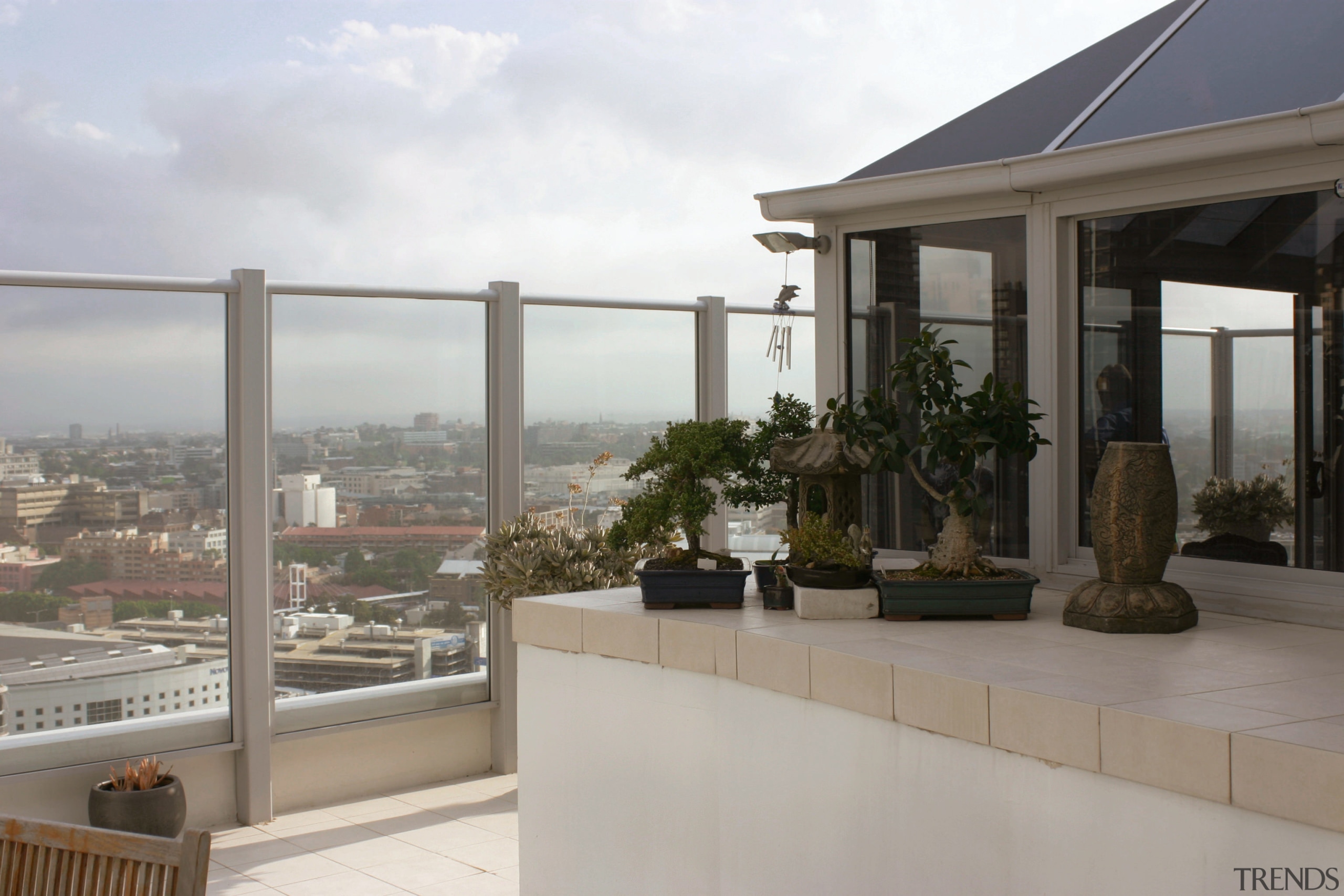 An exteior view of a conservatory, large white apartment, balcony, home, outdoor structure, property, real estate, roof, window, gray, white