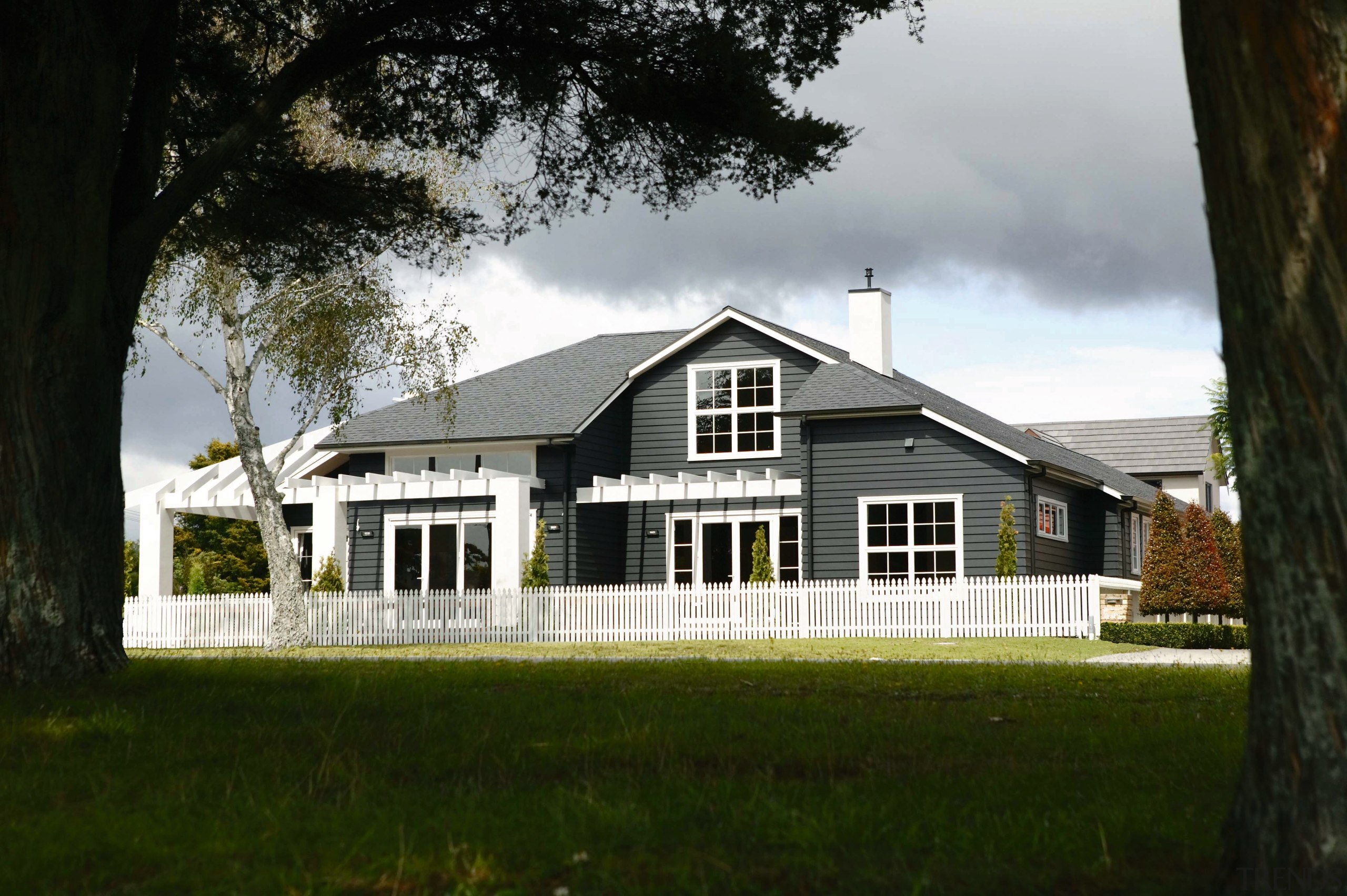 A view of a home designed and built building, cottage, estate, facade, farmhouse, grass, home, house, plantation, property, real estate, residential area, tree, window, black, gray