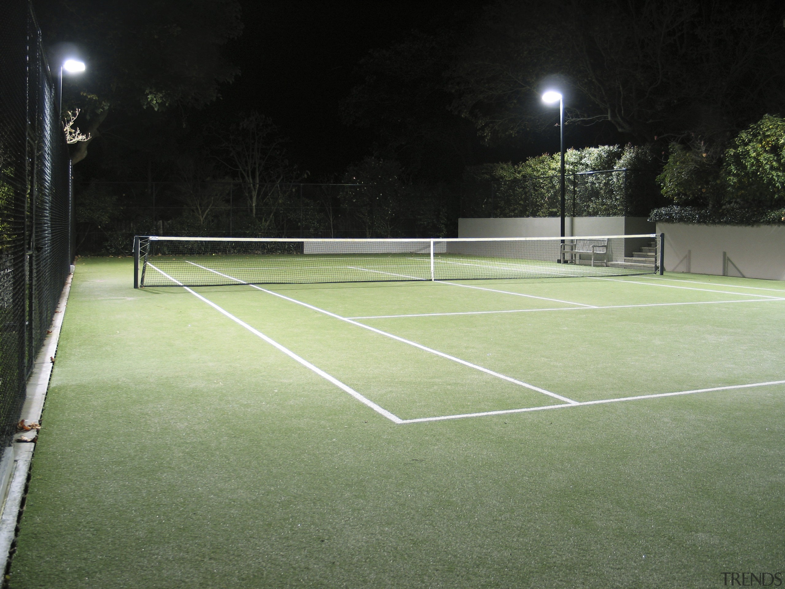 Image of a residential tennis court which was artificial turf, ball game, grass, net, plant, racquet sport, real tennis, sport venue, sports, structure, tennis, tennis court, green, black