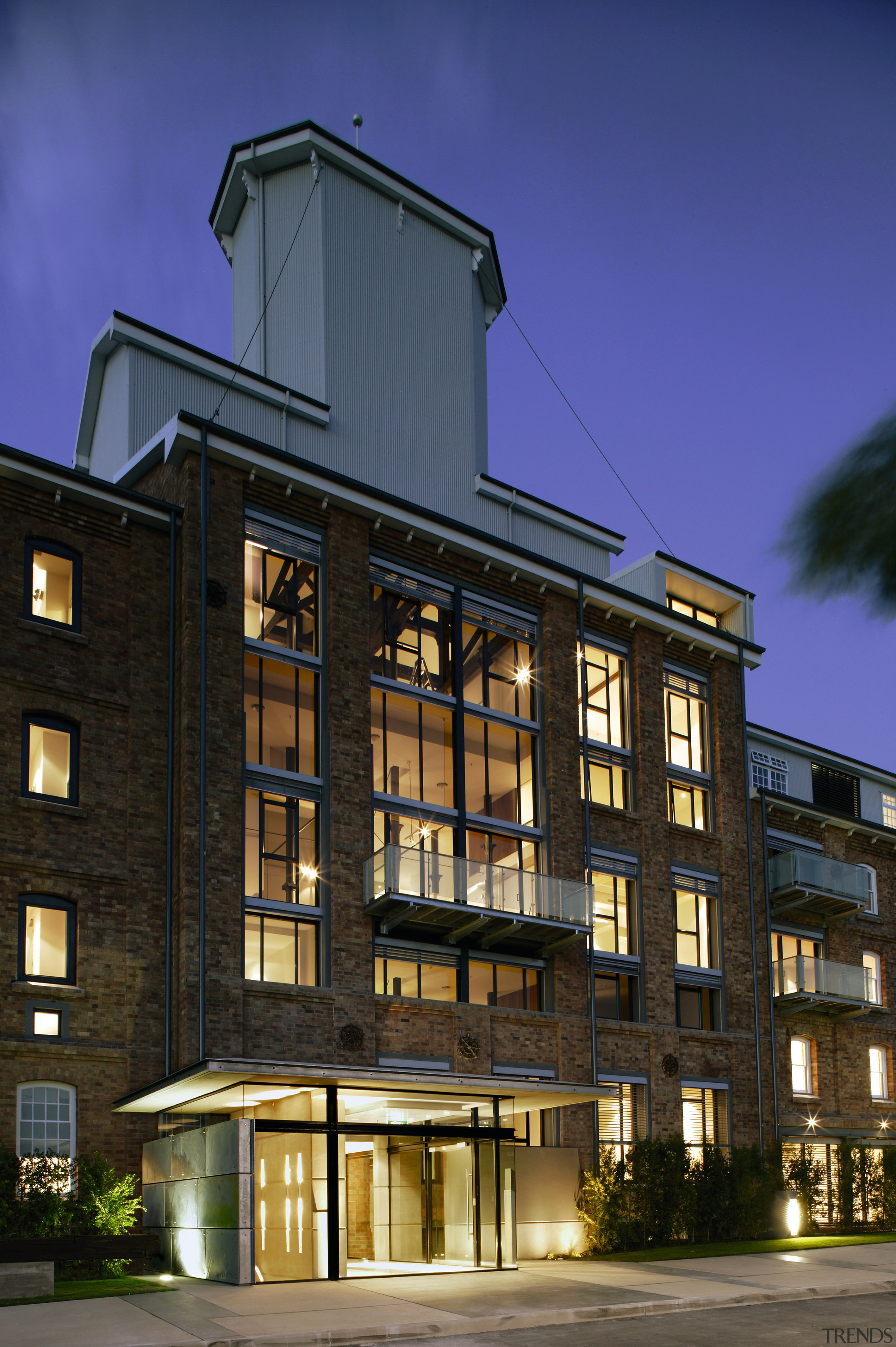 An exterior view of the apartments, brick walls, apartment, architecture, building, city, commercial building, condominium, corporate headquarters, facade, home, house, metropolitan area, mixed use, night, real estate, residential area, window, black, blue