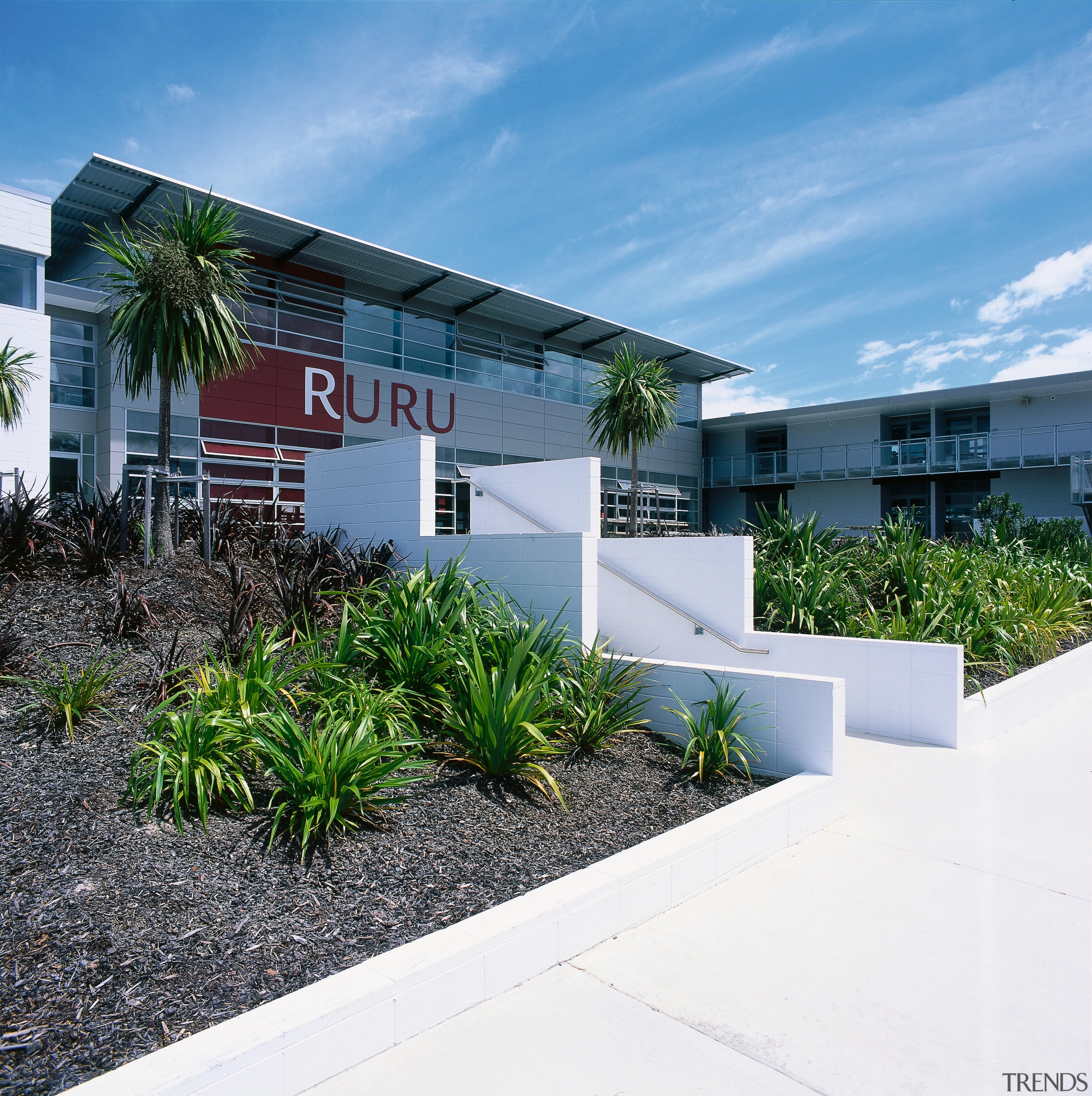 Exterior view of classroom buildings with Ruru signage. architecture, condominium, corporate headquarters, estate, facade, home, house, property, real estate, residential area, teal, white