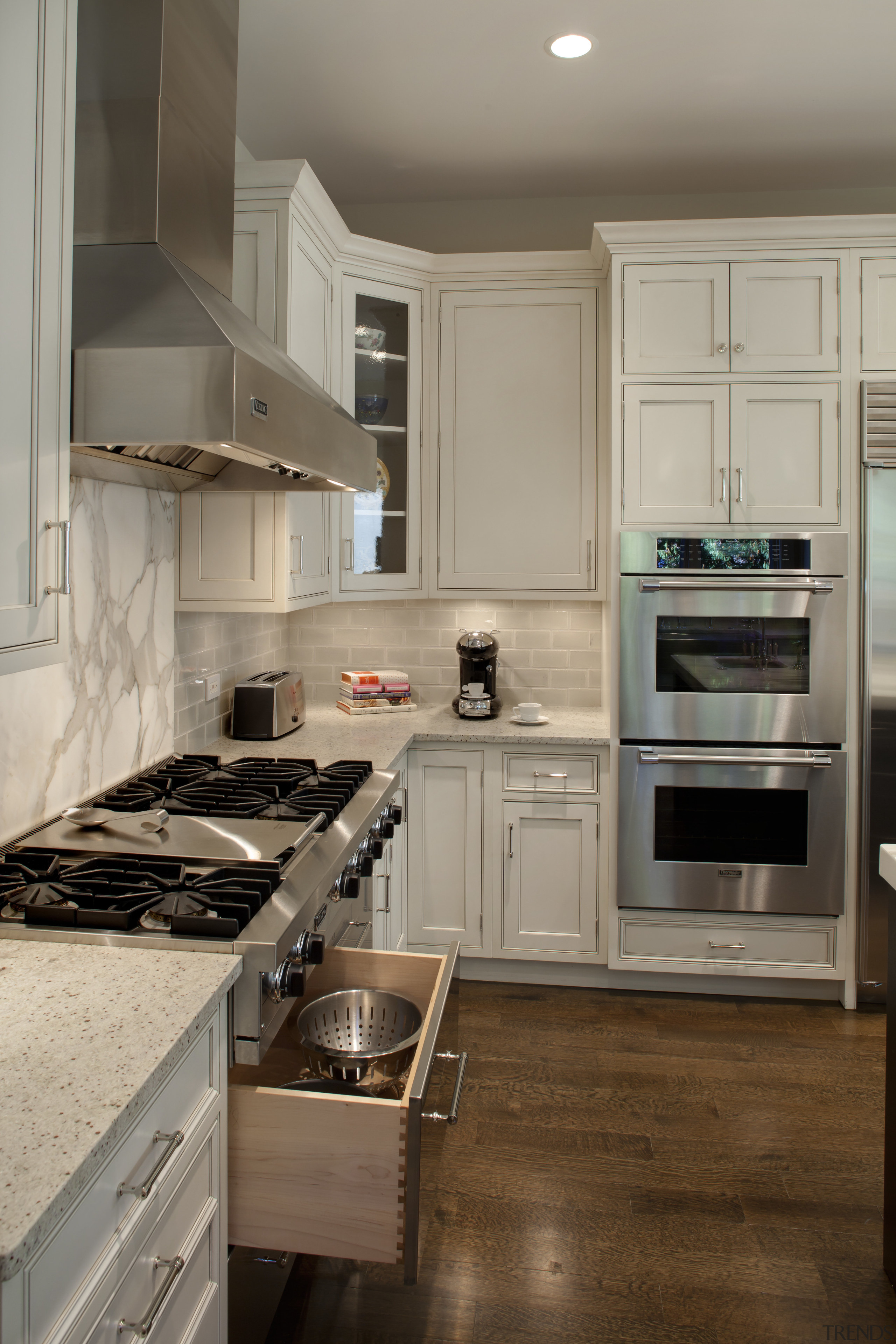 View of kitchen with wooden flooring, stainless drawers cabinetry, countertop, cuisine classique, floor, flooring, hardwood, home appliance, interior design, kitchen, room, wood flooring, gray, brown