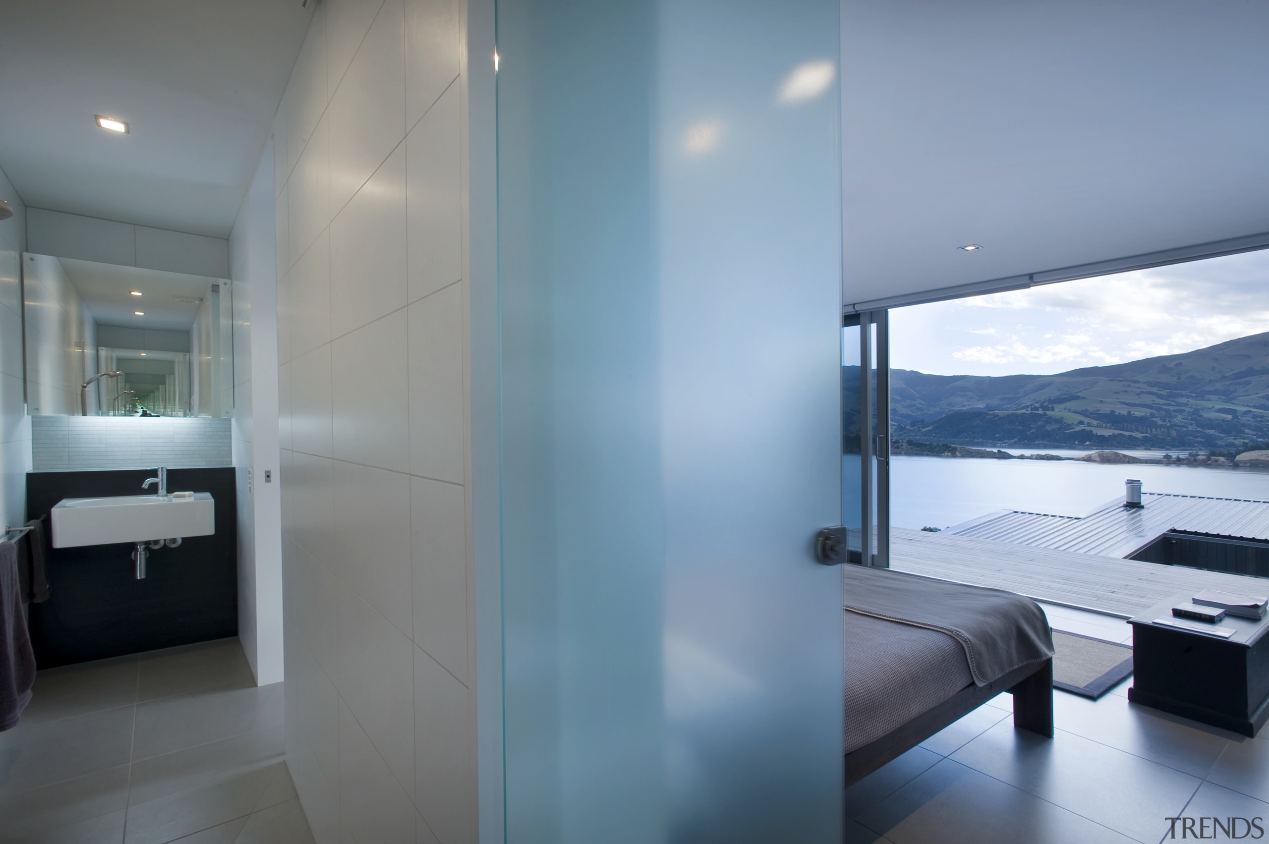 View of bedroom and bathroom with basin, tiled apartment, architecture, ceiling, daylighting, floor, house, interior design, real estate, room, suite, window, gray, teal