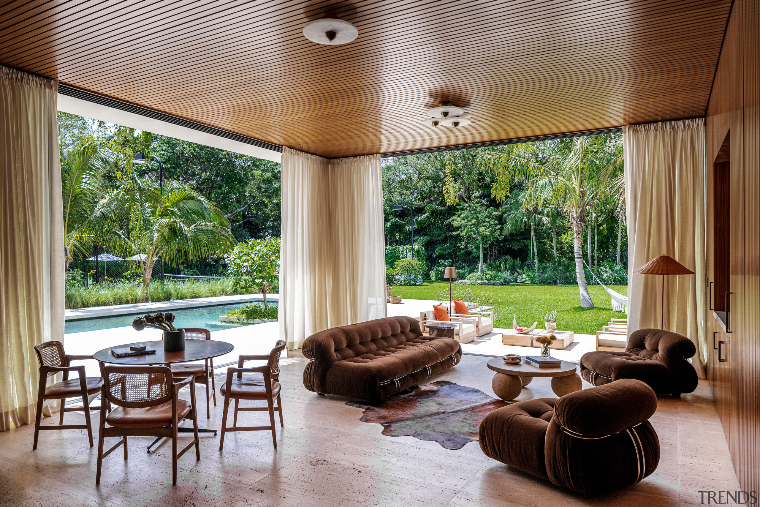 The living room's expansive, floor-to-ceiling openings allow for 