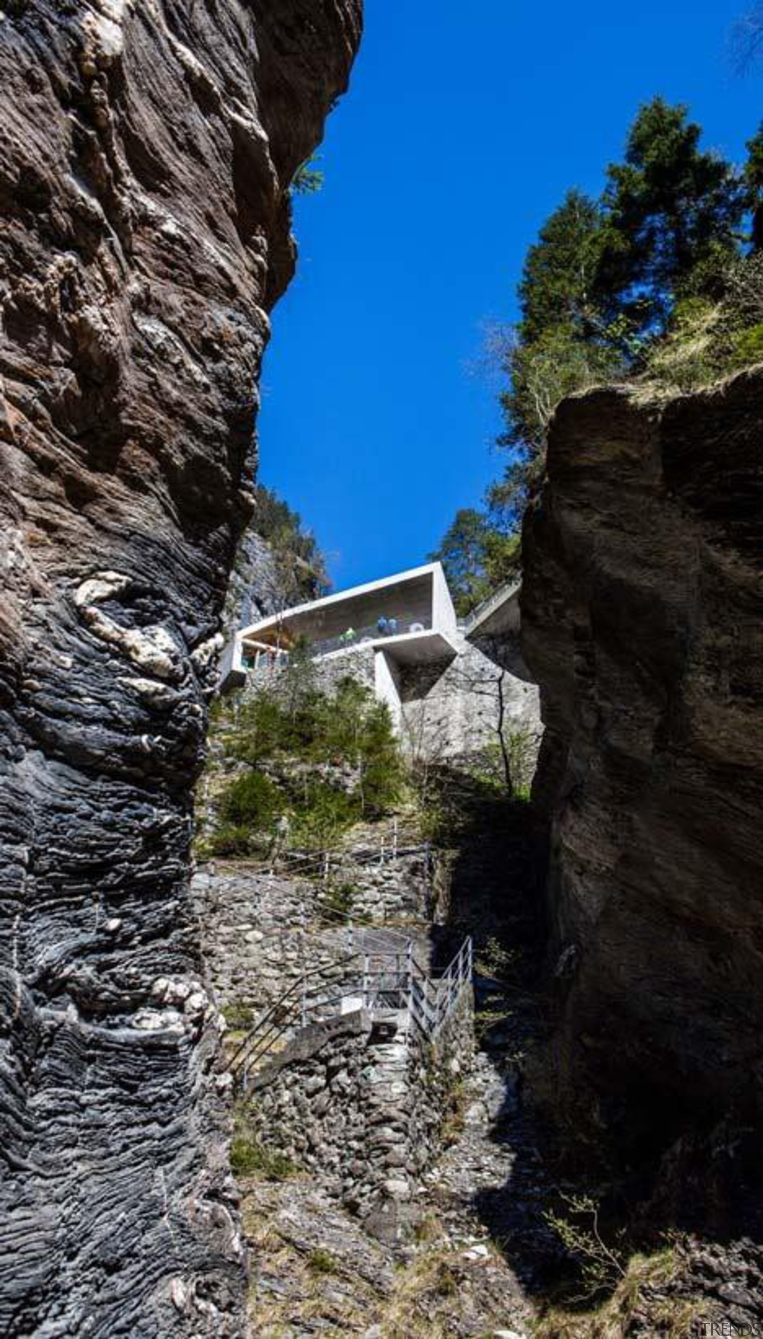 The visitor centre located at the top of cliff, escarpment, formation, geology, mountain, rock, sky, terrain, tree, black, gray