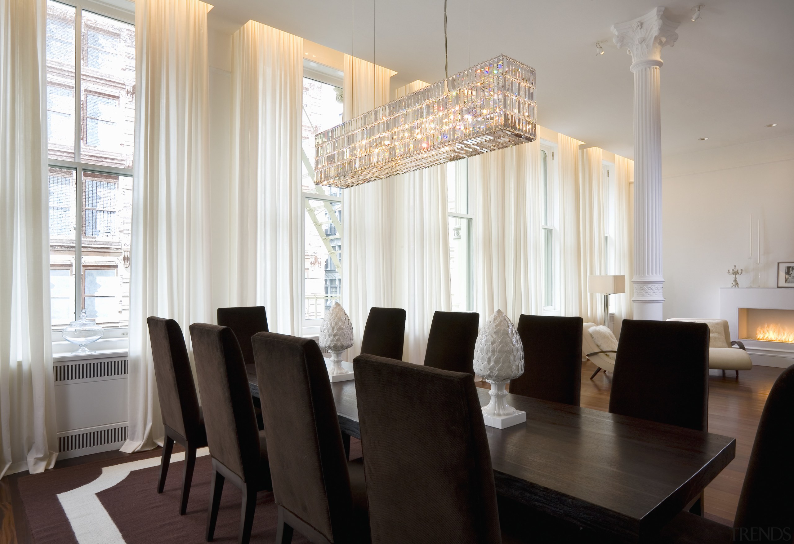 View of the dining room featuring floor length apartment, ceiling, chandelier, curtain, dining room, furniture, home, interior design, light fixture, property, real estate, room, table, window, window covering, window treatment, gray, black