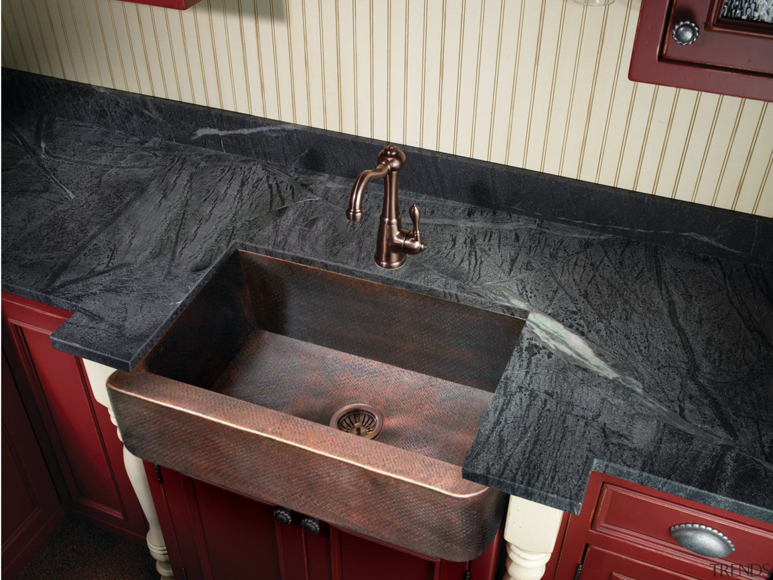 View of kitchen which features sink and arched countertop, floor, plumbing fixture, sink, wood, wood stain, black