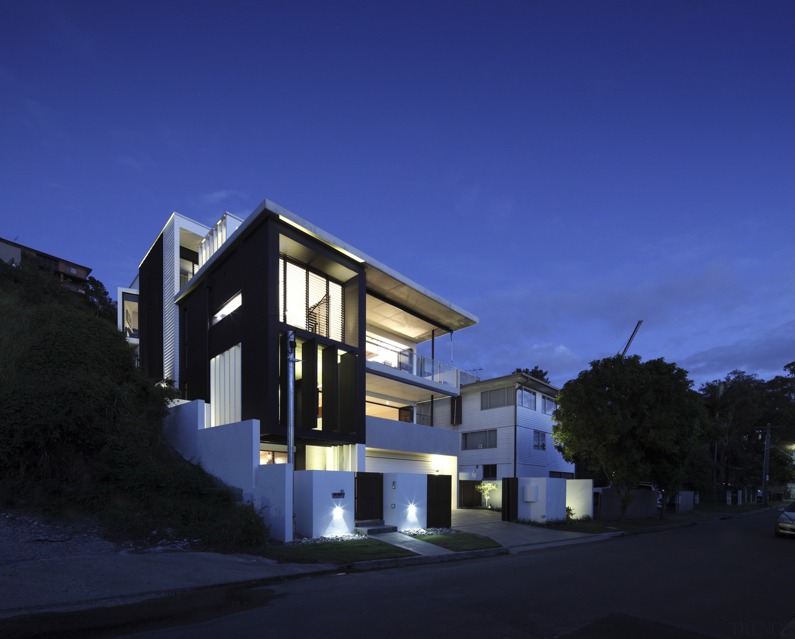 This modern four-level house steps down a steep apartment, architecture, building, condominium, corporate headquarters, facade, home, house, mixed use, property, real estate, residential area, sky, blue, black