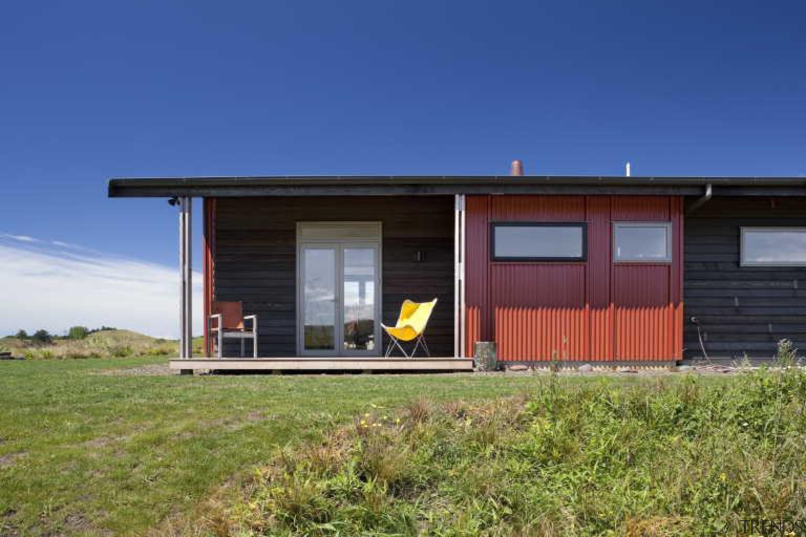 Exterior view of red wall and yellow folding-chair cottage, facade, home, house, property, real estate, shack, shed, sky, blue