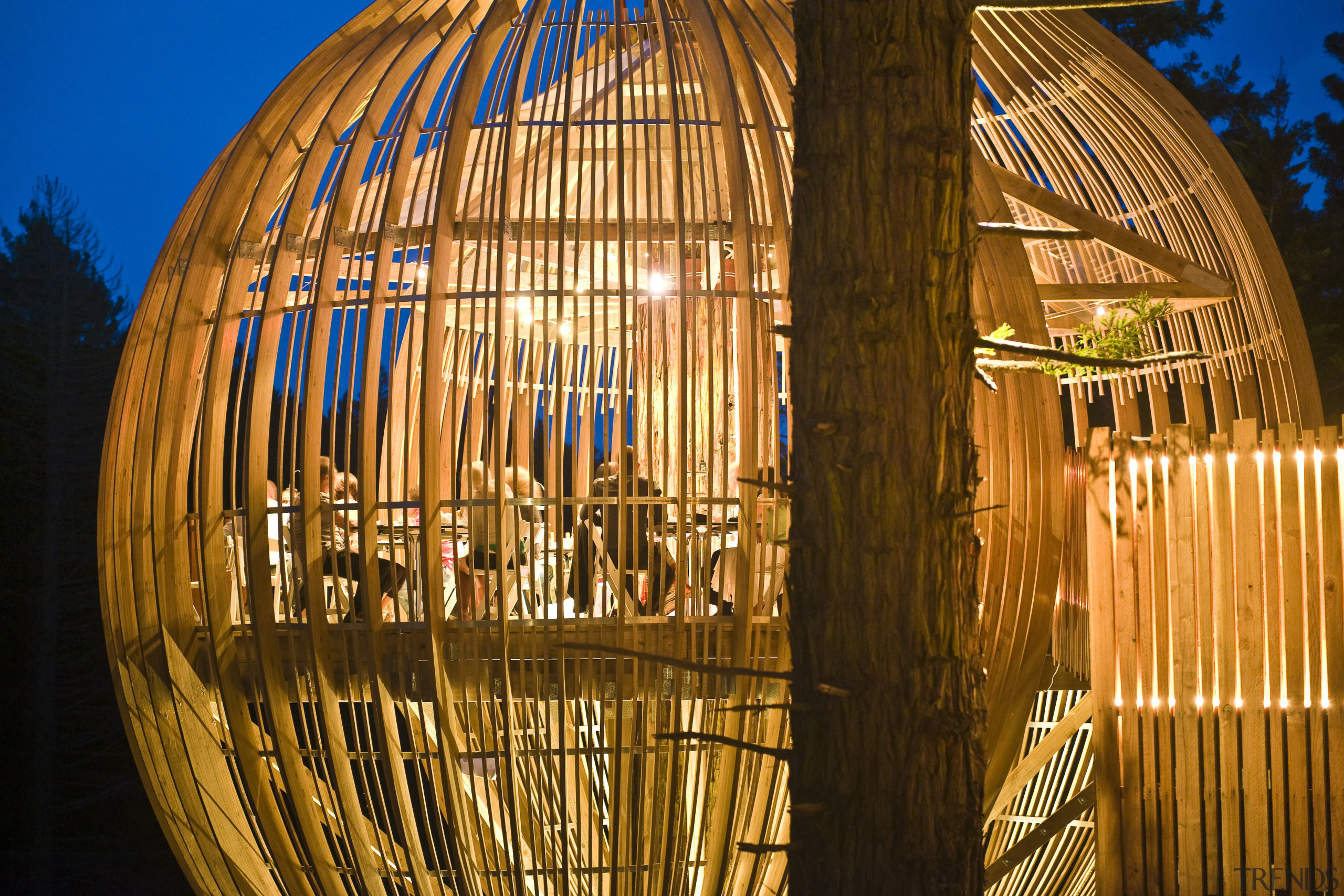 Image of the Yellow Treehouse restaurant which has architecture, landmark, light, lighting, night, reflection, sky, structure, tourist attraction, wood, brown, orange