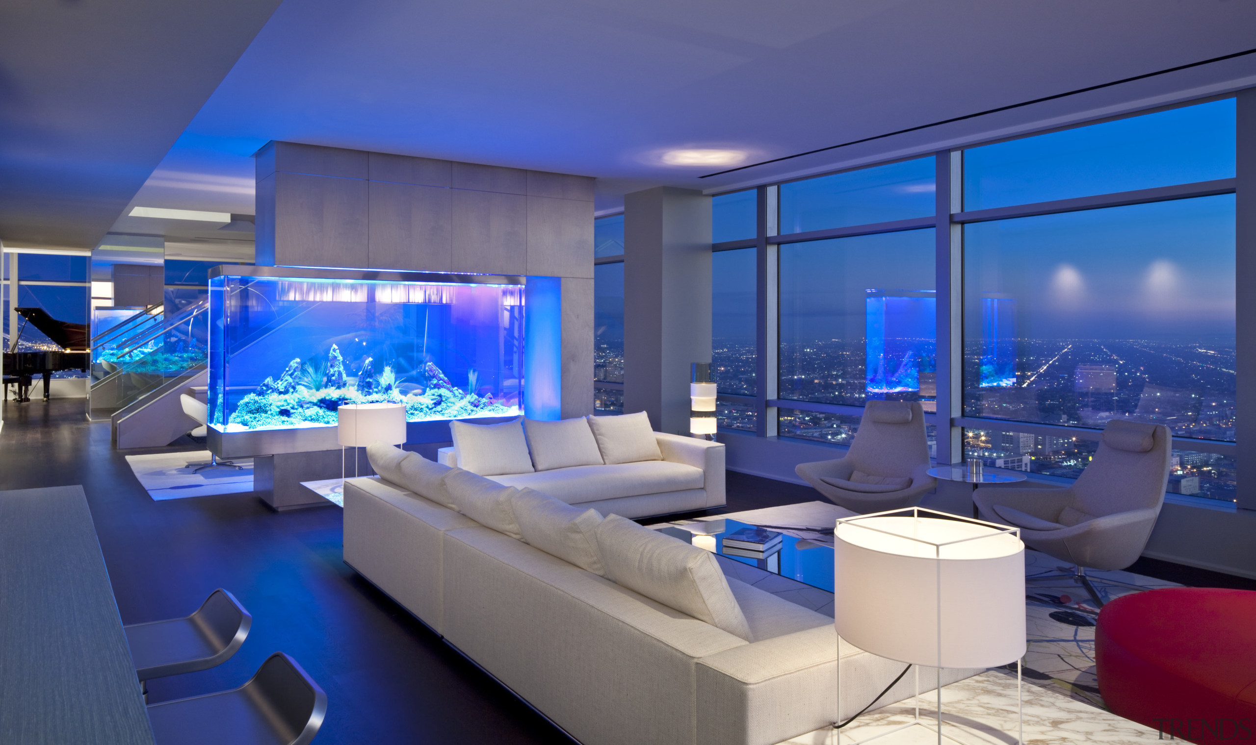 An 850-gallon aquarium serves as a partition between architecture, blue, home, interior design, lighting, living room, blue