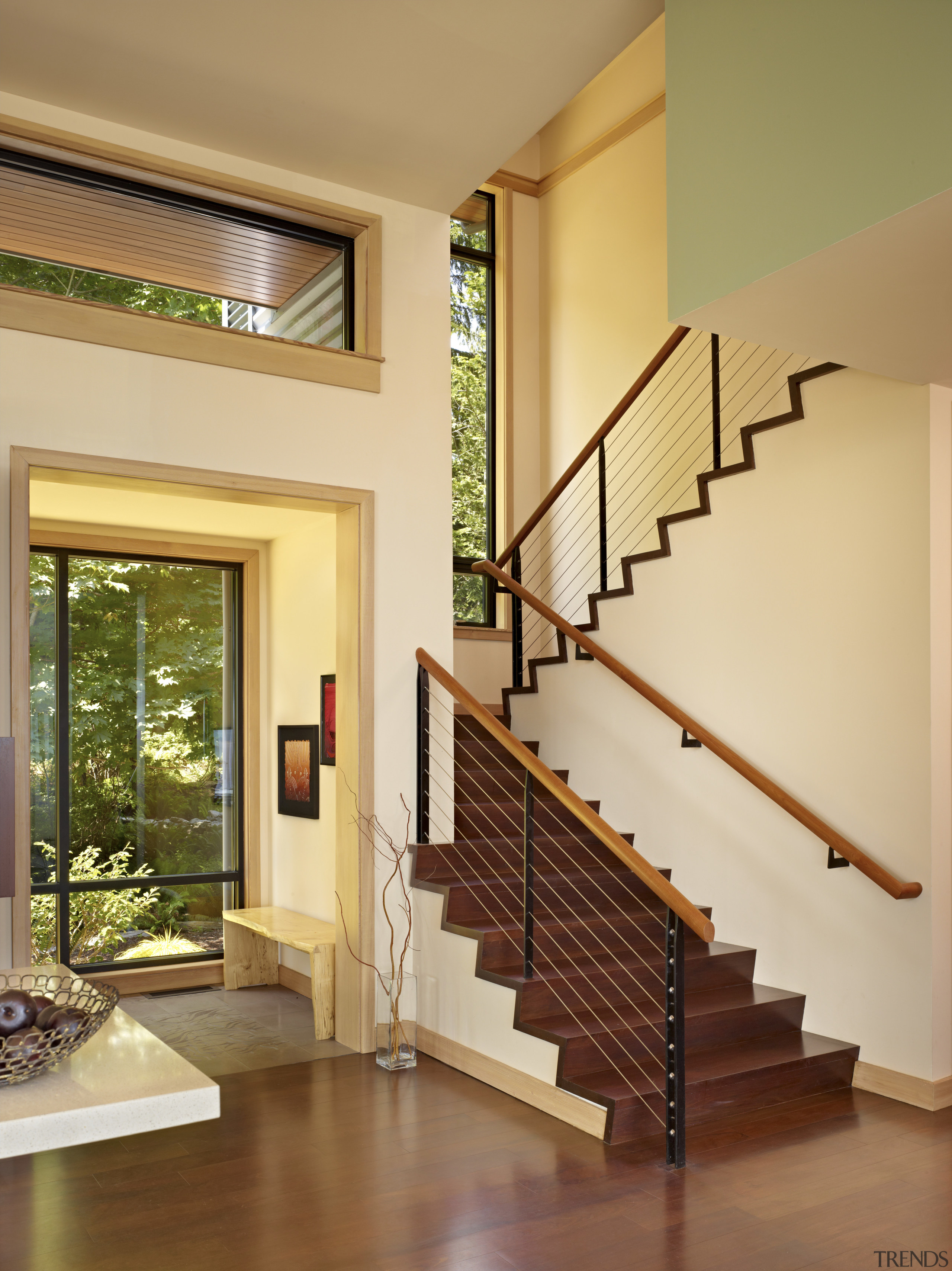 The stairway to the master suite is beside architecture, ceiling, floor, handrail, hardwood, home, house, interior design, living room, real estate, stairs, wall, window, orange, brown