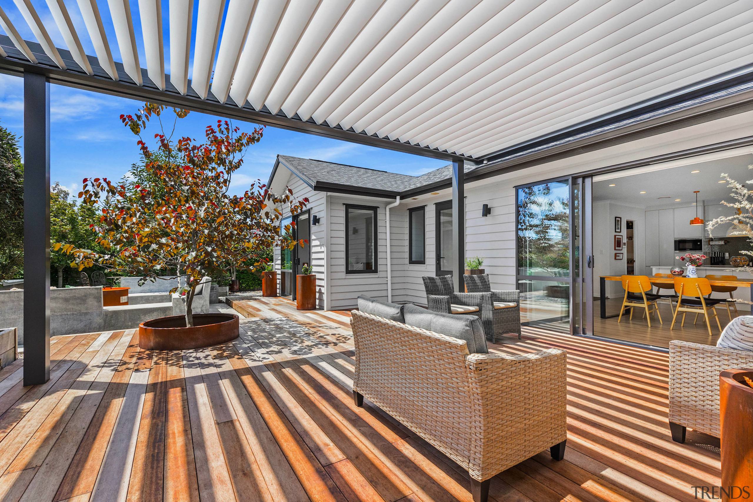 A pergola forms the central spine, casting shifting 