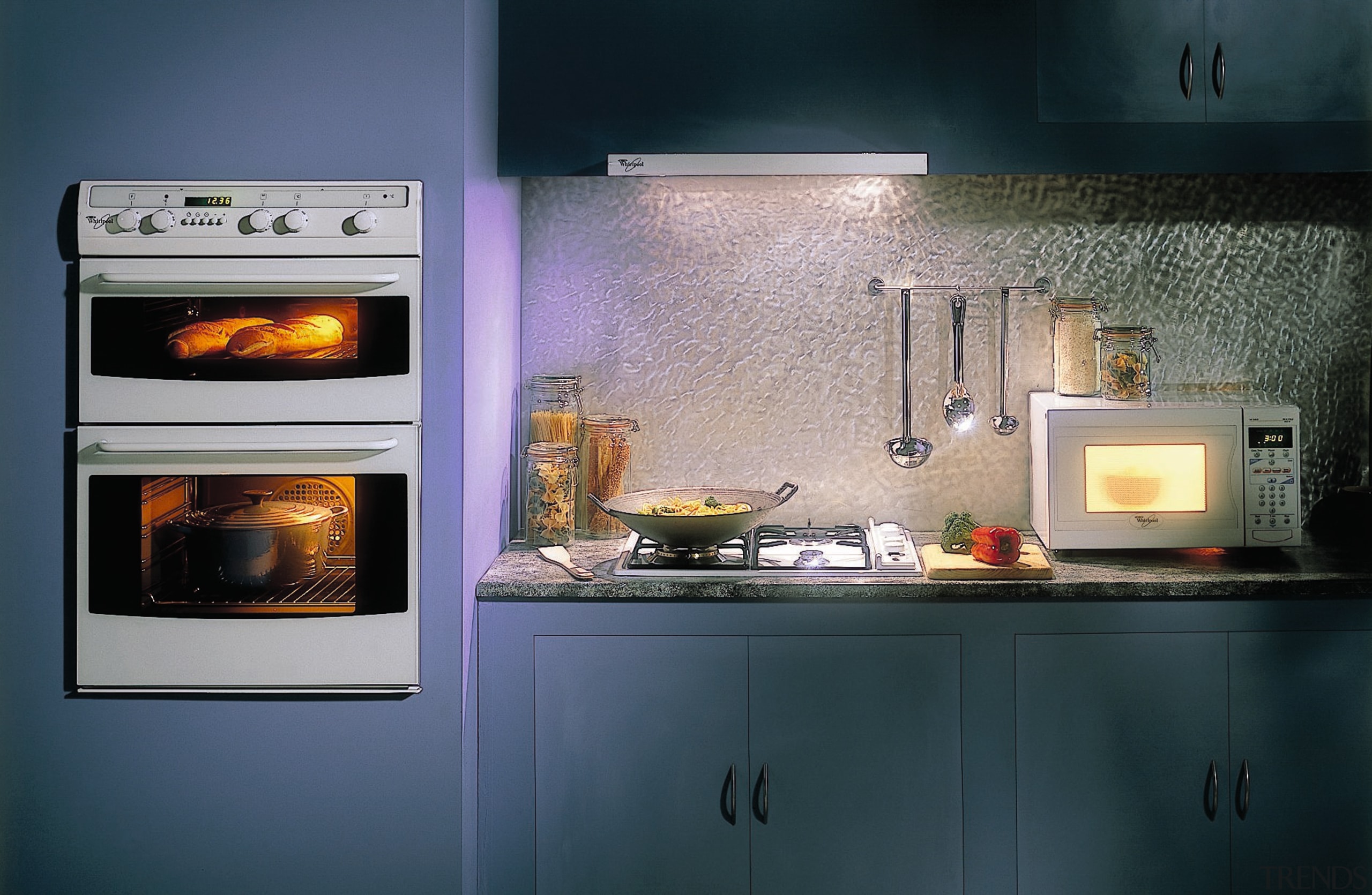 Kitchen featuring light blue cabinetry, wall ovens, cooktop, hearth, home appliance, kitchen, kitchen appliance, kitchen stove, major appliance, oven, wood burning stove, black, gray