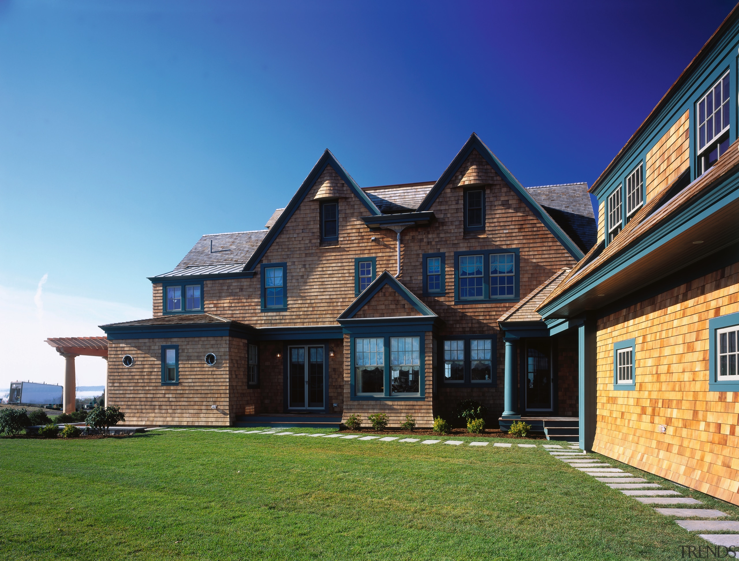 View of the wooden shingled house, lawn, green building, cottage, elevation, estate, facade, farmhouse, home, house, property, real estate, residential area, roof, siding, sky, window