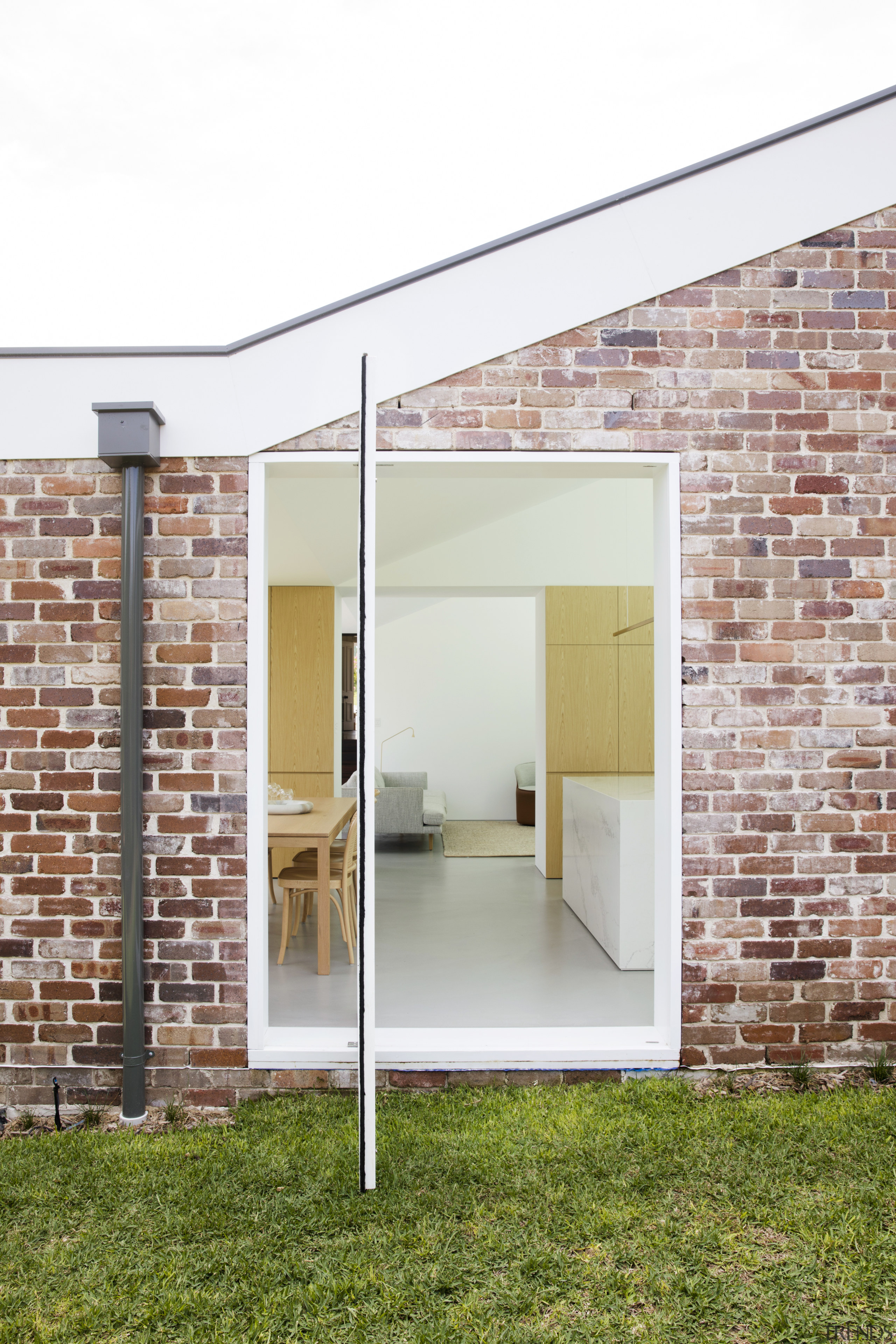 A contemporary pivot door is set into a architecture, daylighting, door, facade, house, real estate, wall, window, white