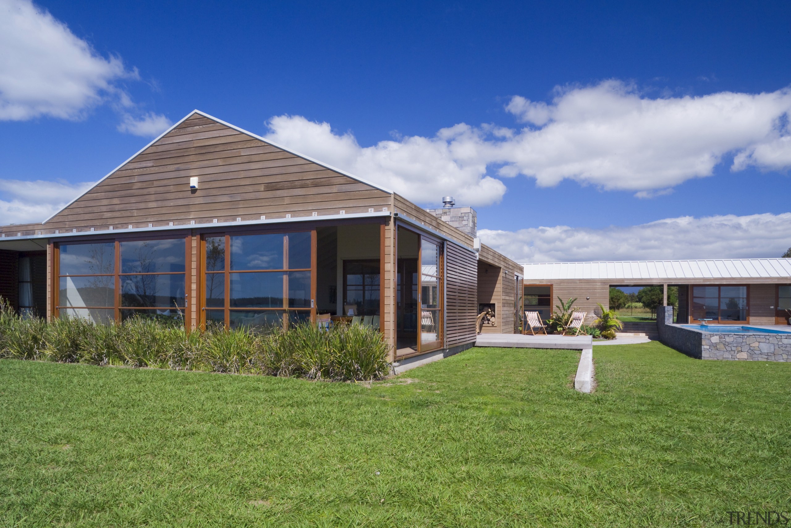 This coastal holiday home draws on rural forms cottage, elevation, estate, facade, farmhouse, grass, home, house, land lot, landscape, property, real estate, residential area, roof, siding, sky, green