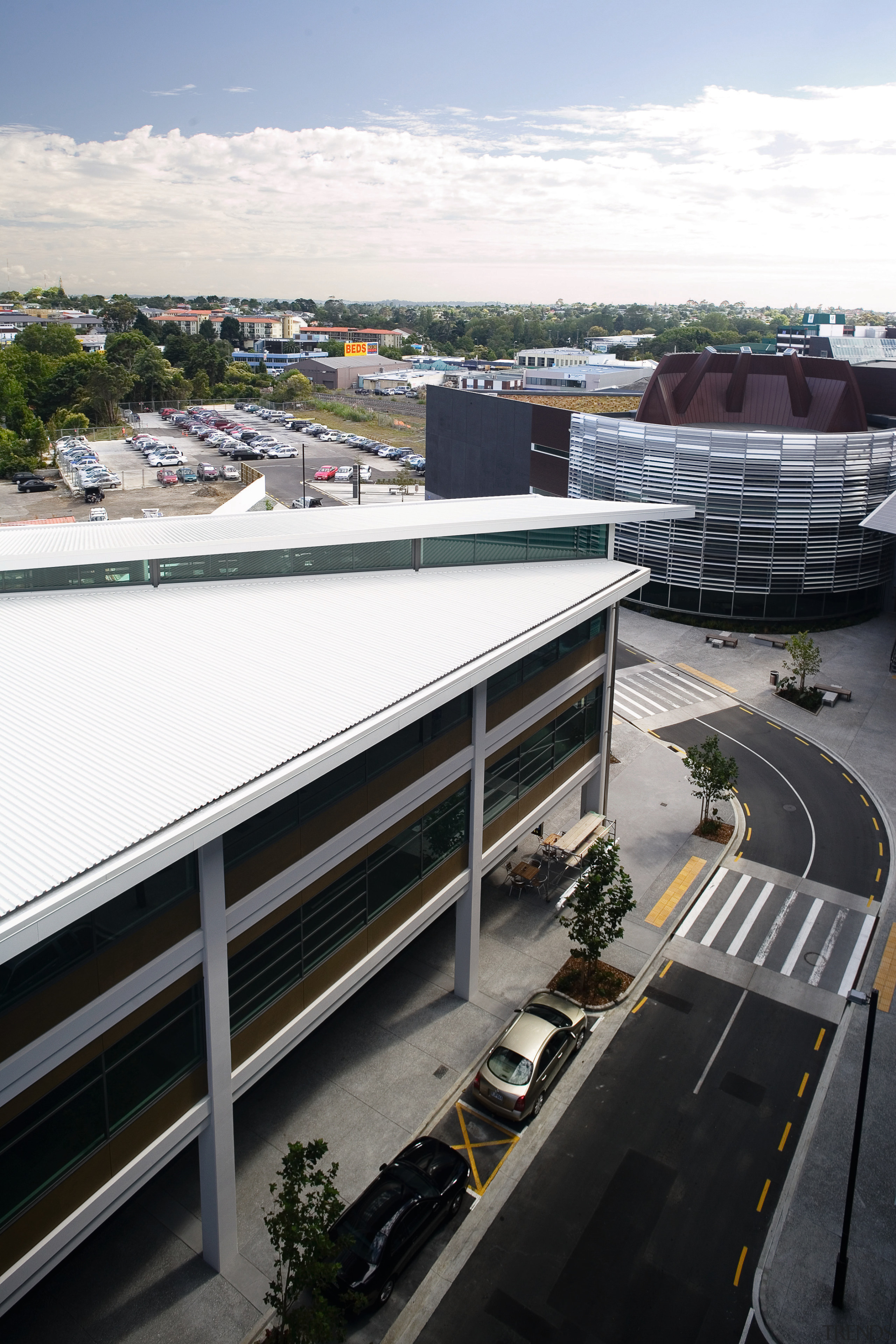 View of this commercial office centre, buidings featuring architecture, building, city, infrastructure, metropolitan area, real estate, road, roof, sky, transport, urban area, white, black