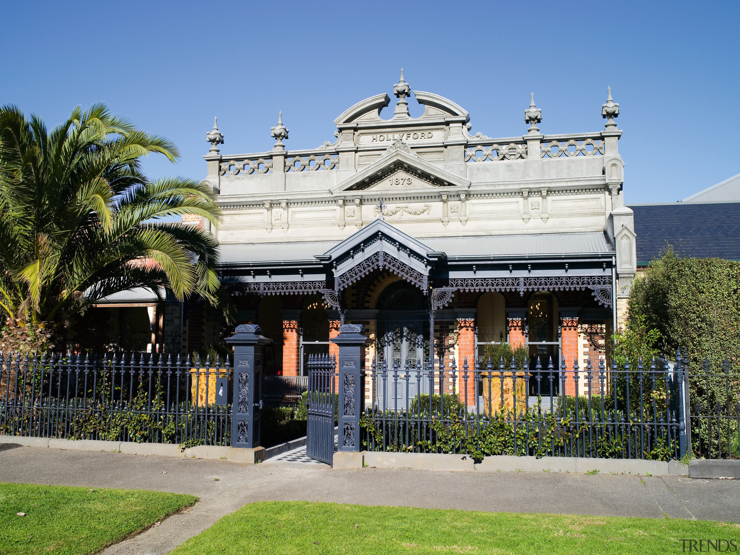 An exterior view of the entrance way to architecture, building, estate, facade, historic site, home, house, landmark, mansion, palace, palm tree, plant, real estate, residential area, sky, tree, villa