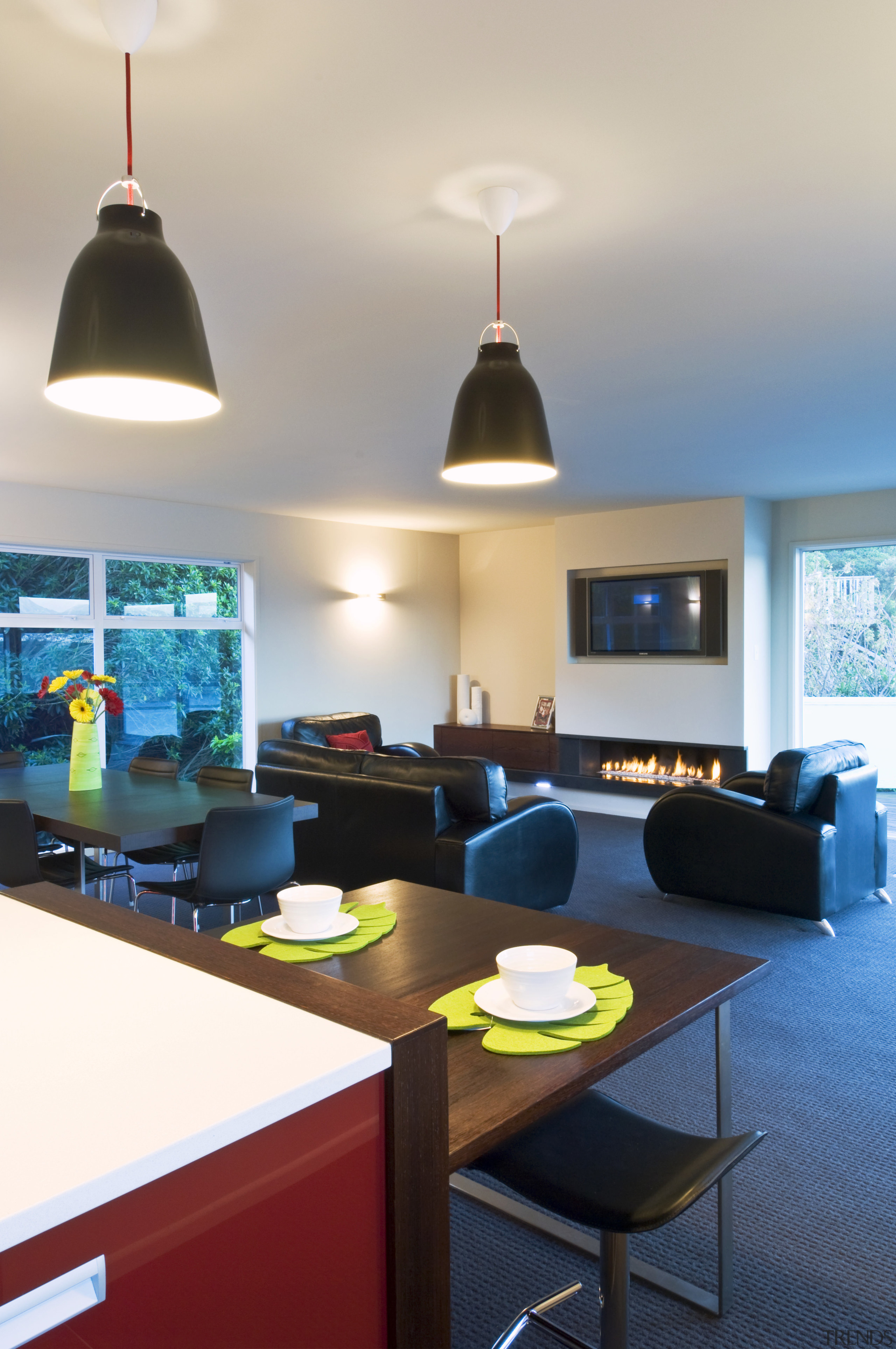 View of open-planned kitchen which features a kitchen ceiling, furniture, interior design, light fixture, lighting, living room, room, table, white