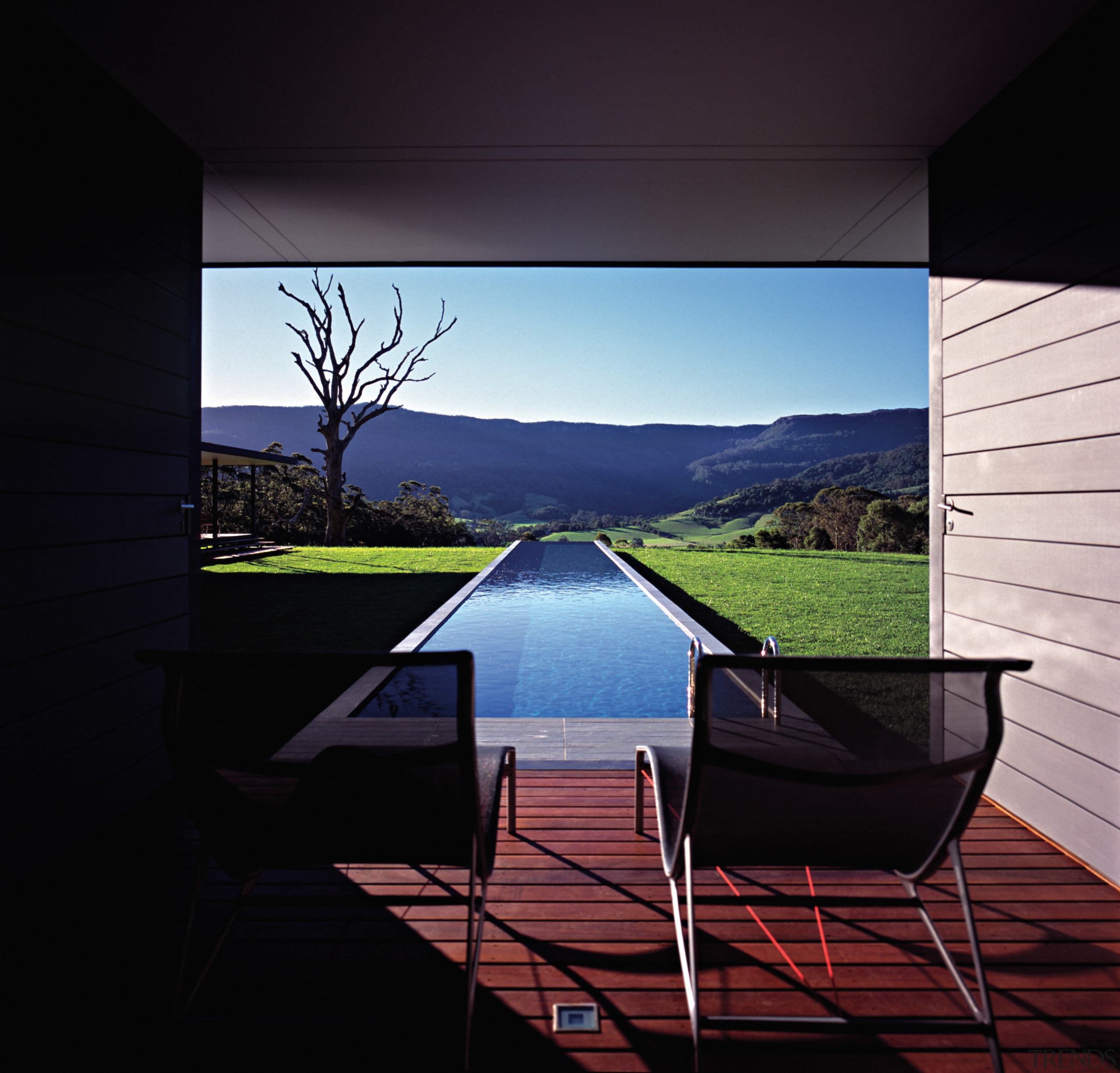 An exterior view of this architecturally designed home architecture, chair, daylighting, furniture, glass, house, interior design, light, lighting, outdoor furniture, reflection, sky, sunlight, table, water, window, black