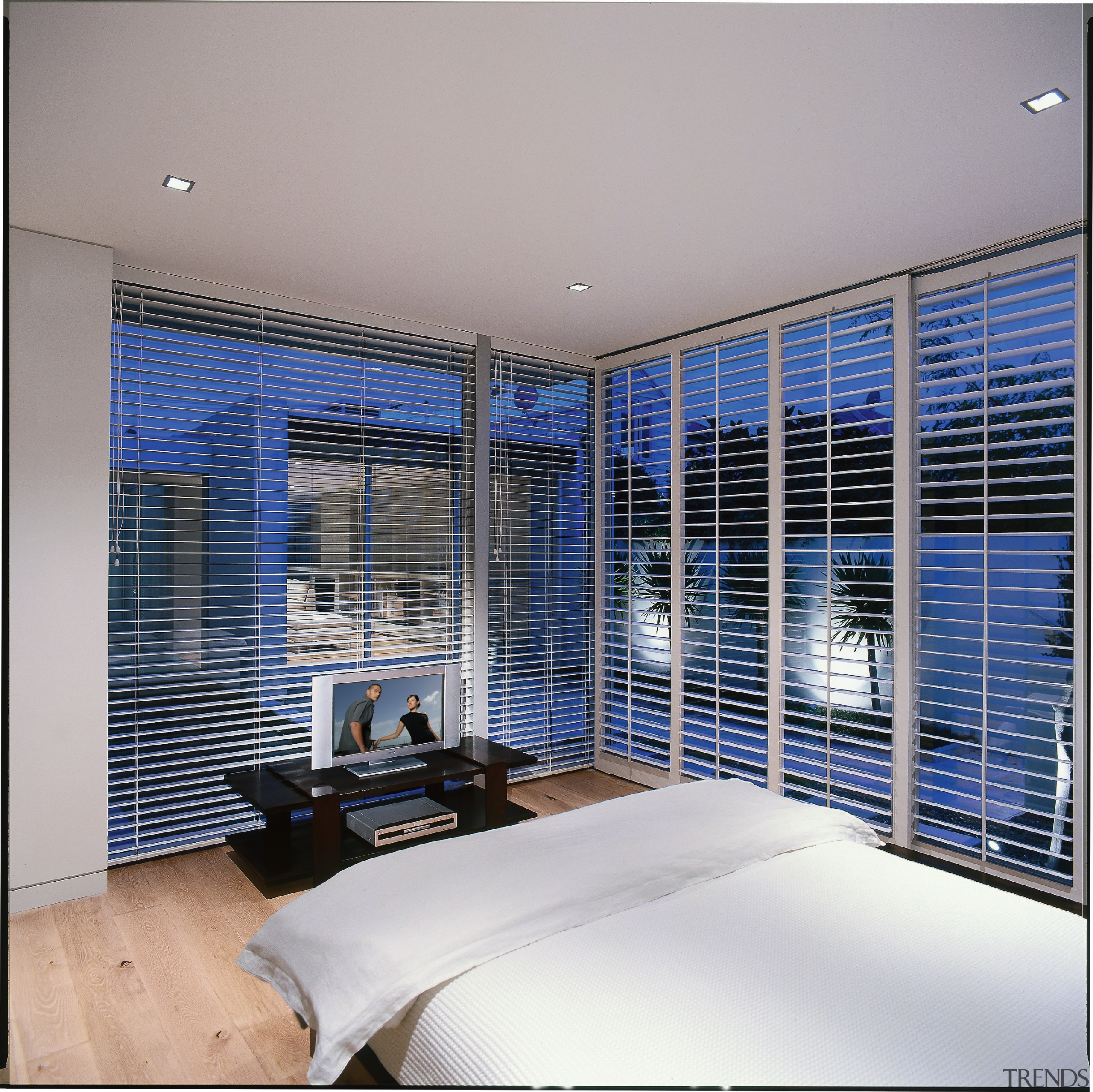 A photograph of a bedroom featuring a DVD architecture, ceiling, condominium, daylighting, interior design, property, real estate, window, window blind, window covering, window treatment, gray