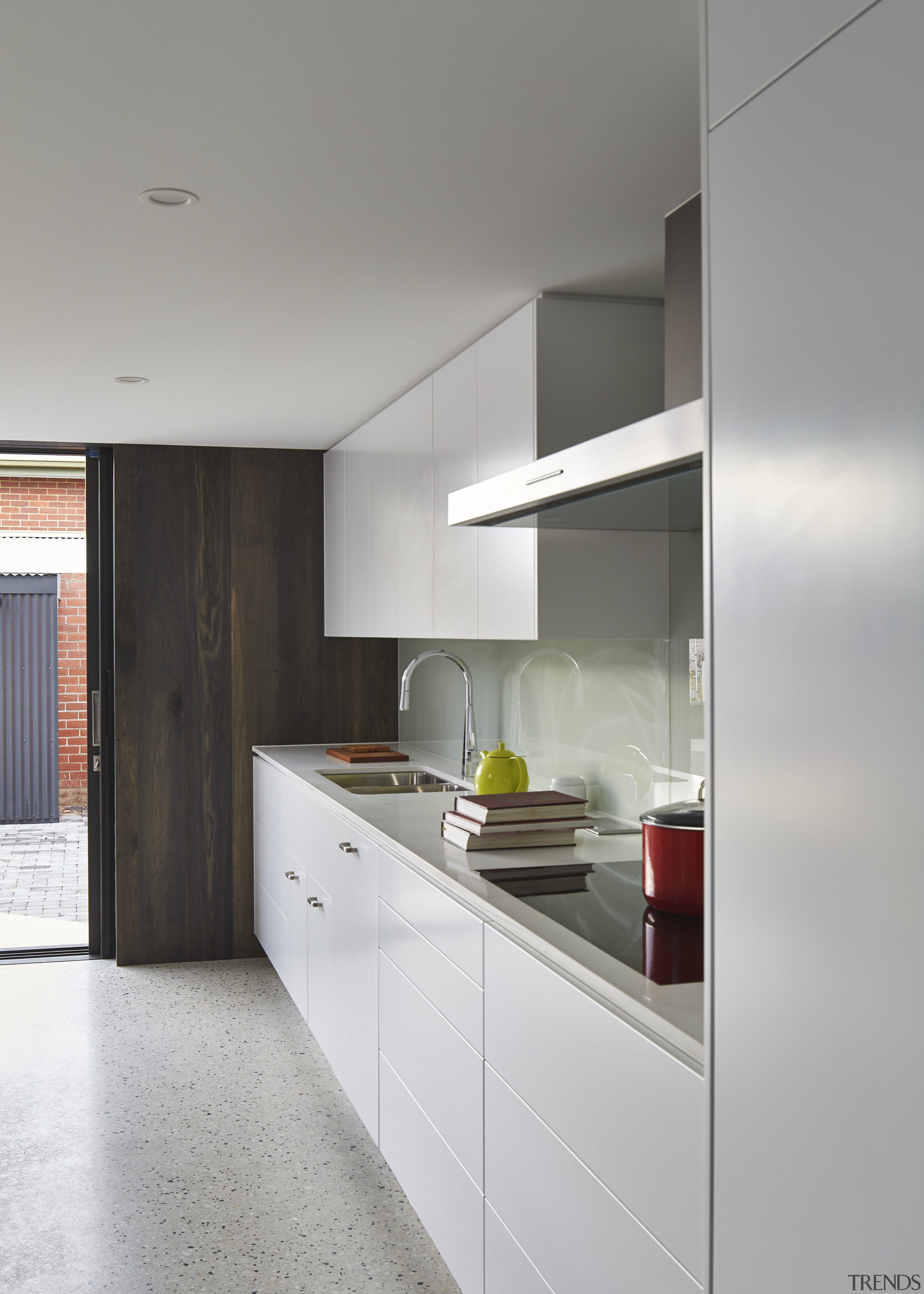 This white kitchen with glass splashback is positioned architecture, cabinetry, countertop, interior design, kitchen, real estate, gray