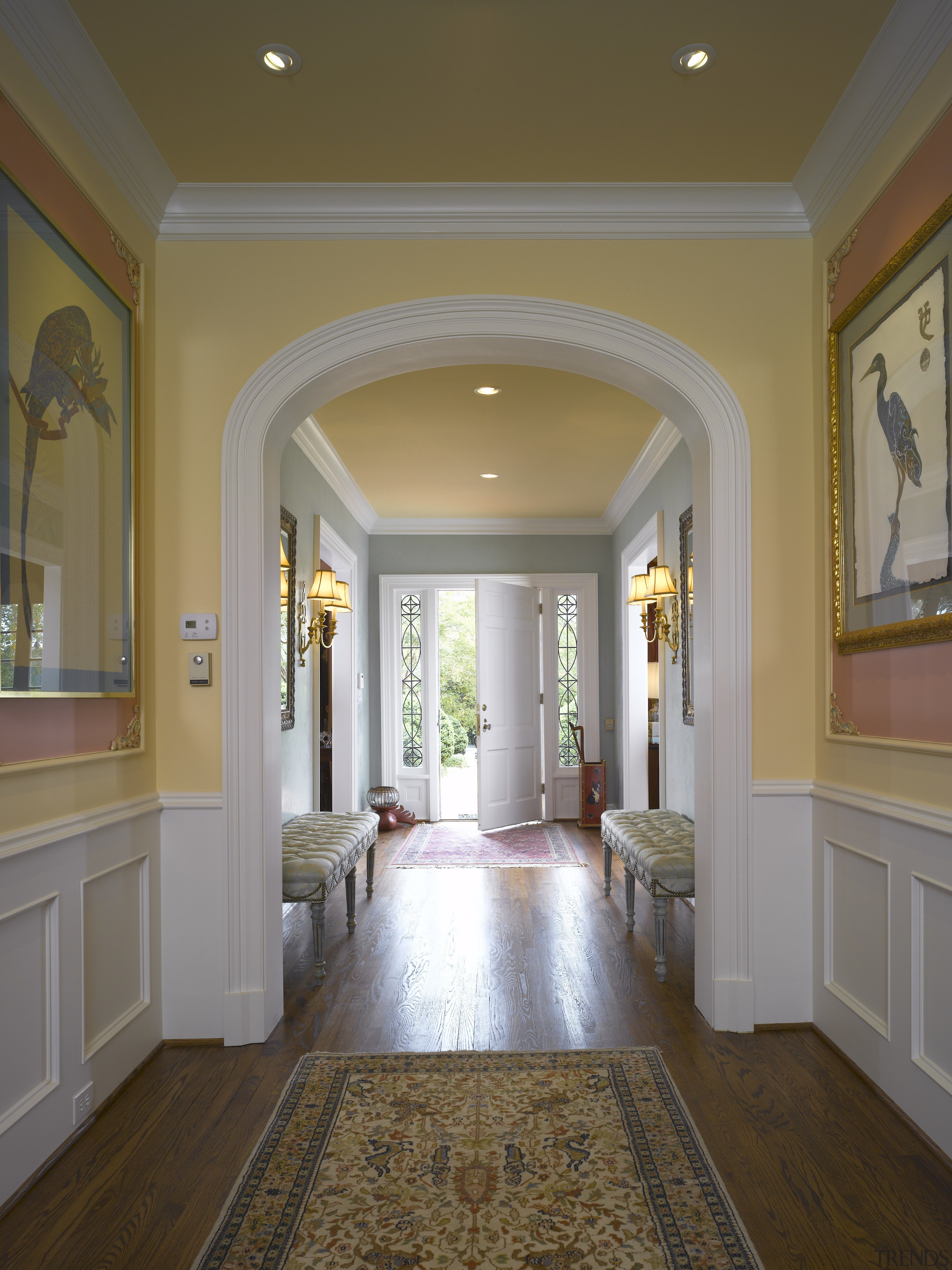 The hallway in this remodeled house is divided ceiling, column, daylighting, estate, floor, flooring, hall, hardwood, home, interior design, laminate flooring, living room, lobby, molding, property, real estate, room, wall, window, wood flooring, brown, gray