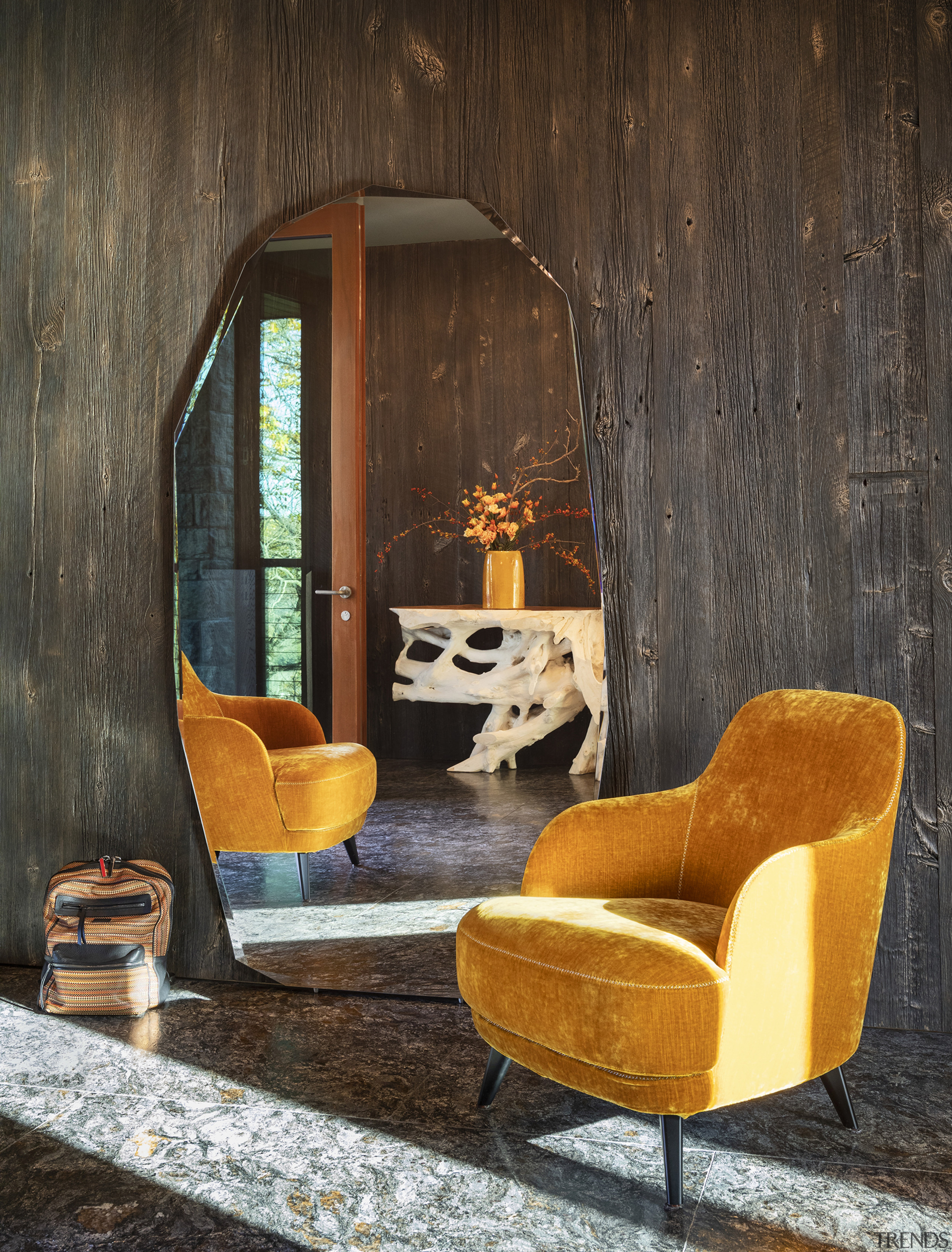 A quirkily shaped mirror rests against a rustic, 