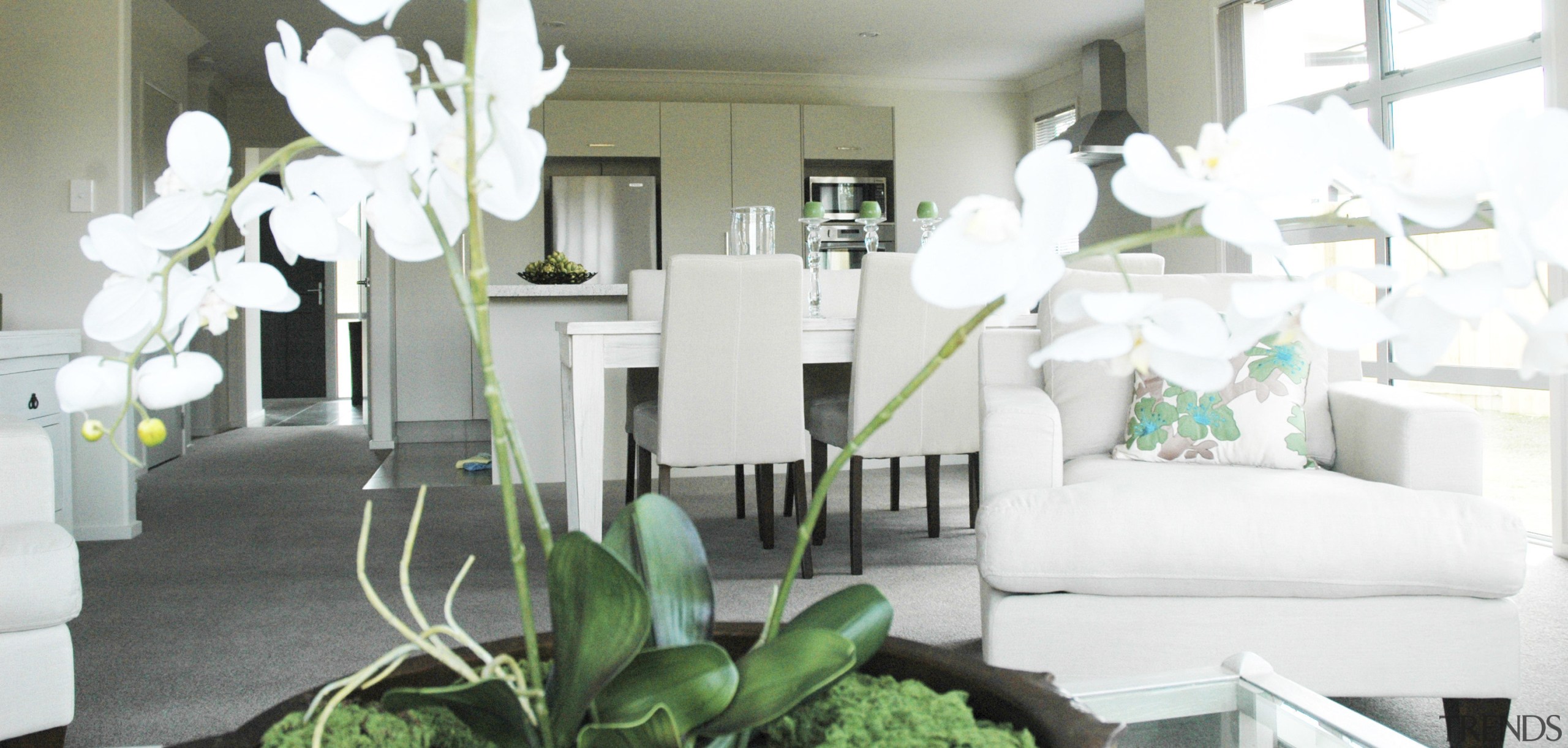 white flowers, dining table beyond. all white - dining room, floristry, flower, furniture, green, home, house, interior design, living room, plant, room, white