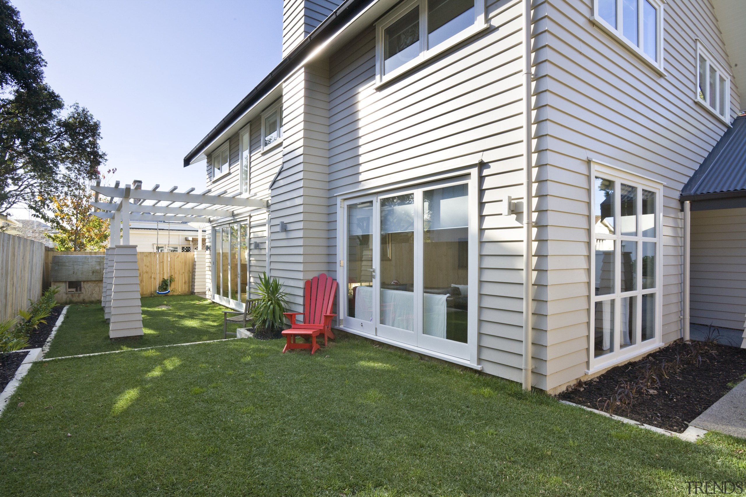 Exterior view of a new home designed by backyard, cottage, facade, grass, home, house, lawn, porch, property, real estate, residential area, siding, window, yard, white