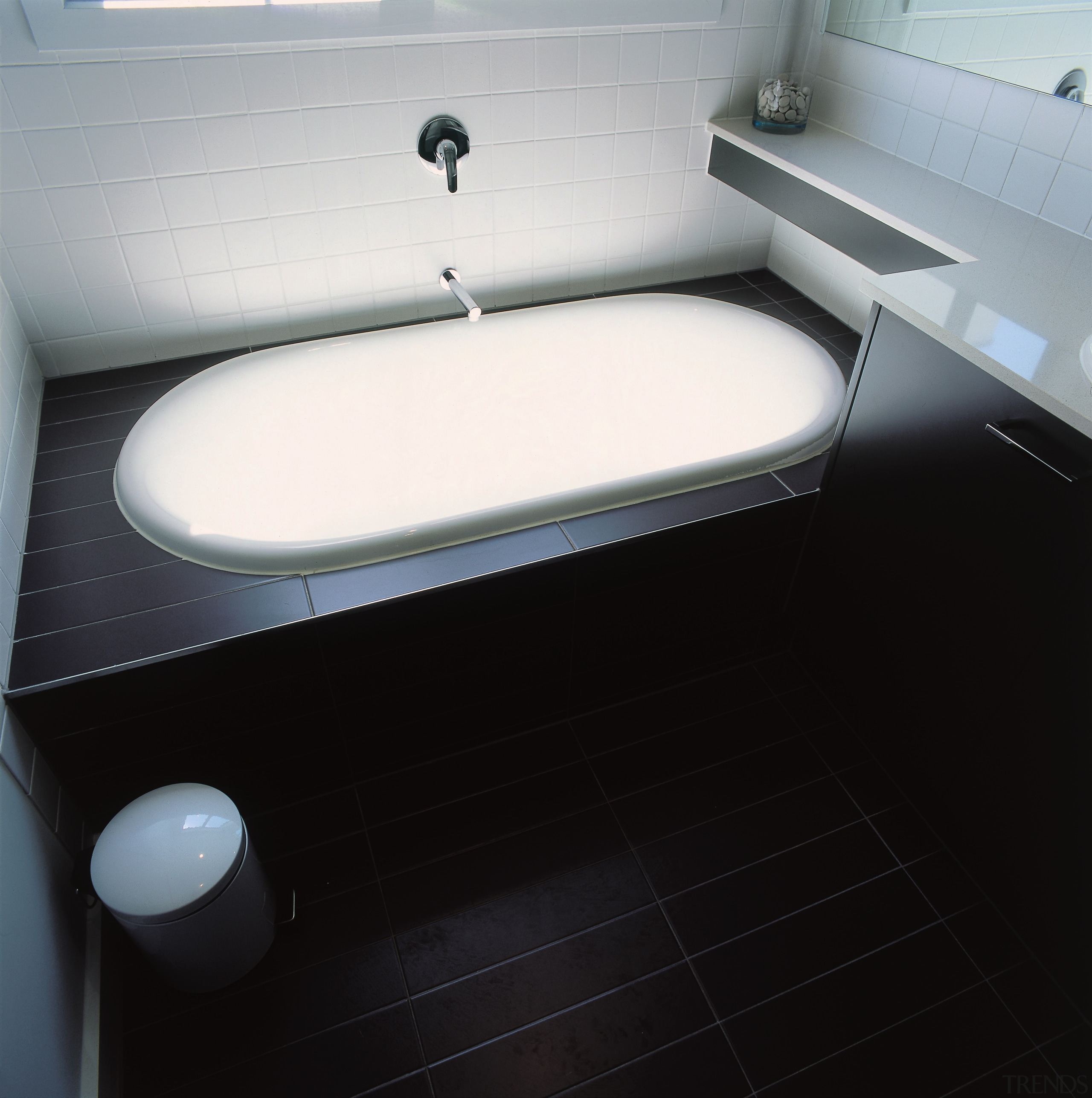 White bath with dark timber surround and flooring. bathroom, bathroom sink, floor, plumbing fixture, product design, sink, toilet, toilet seat, black, gray