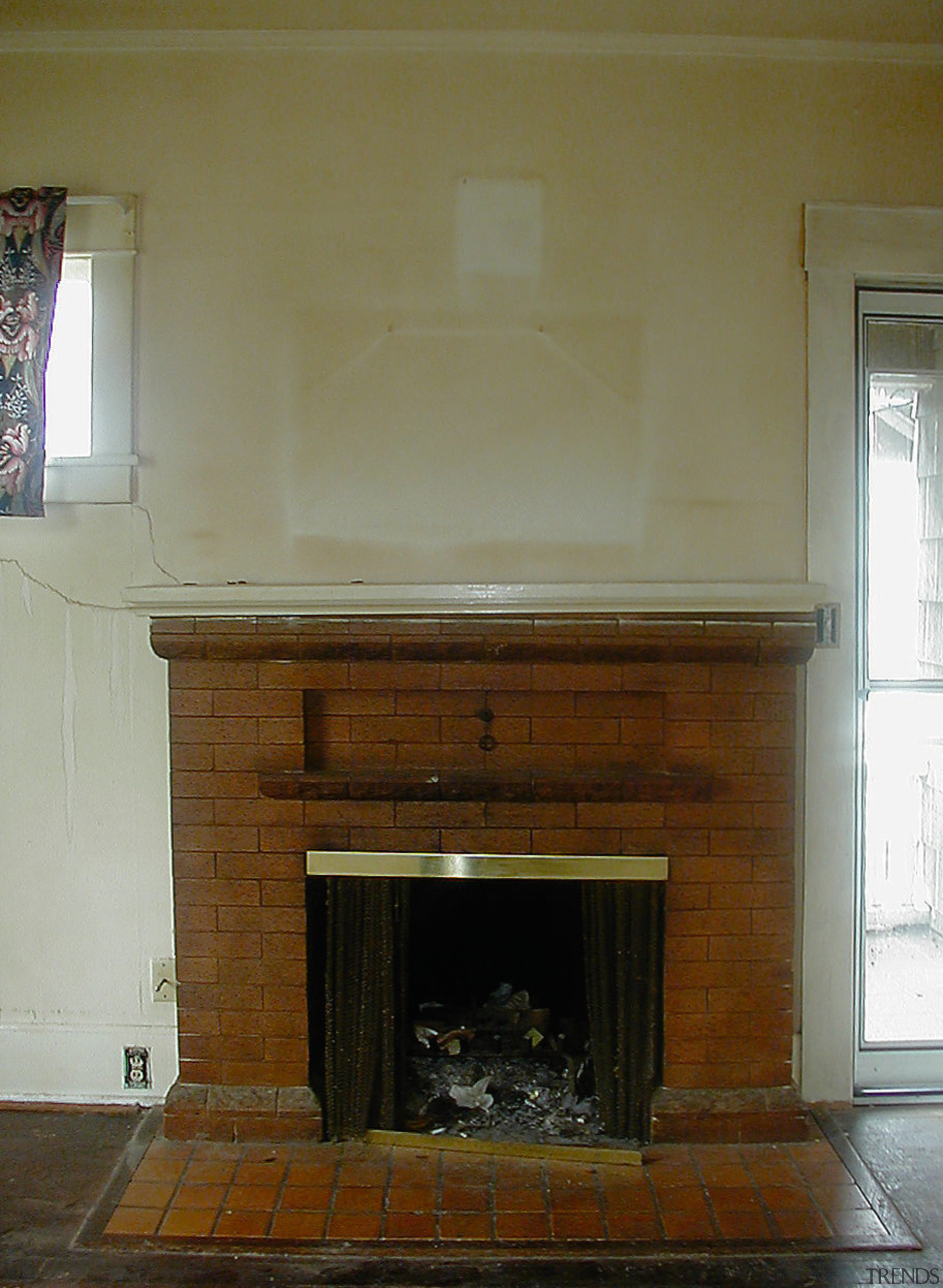 A view of the home before it was fireplace, floor, flooring, hardwood, hearth, home, wall, brown