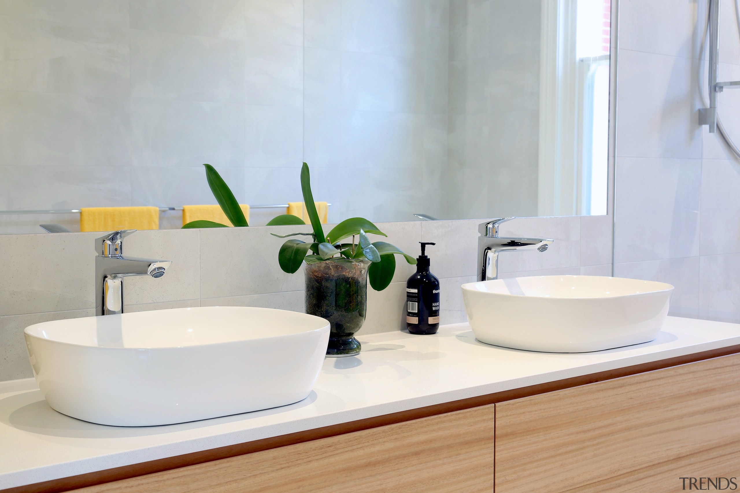 The contemporary design for this bathroom included tabletop architecture, bathroom, bathroom accessory, bathroom cabinet, bathroom sink, ceramic, countertop, floor, flooring, furniture, interior design, material property, plumbing fixture, product, property, room, sink, tap, tile, wall, white, white, gray