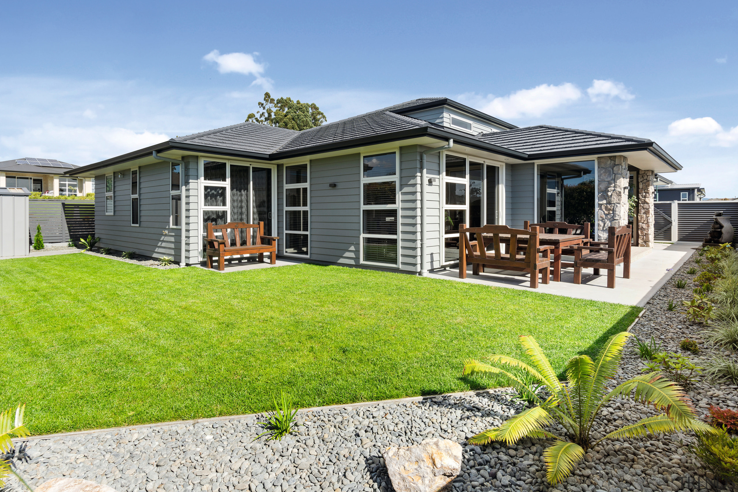 Grey Linea weatherboard and stone accent elements give backyard, cottage, elevation, estate, facade, grass, home, house, landscape, property, real estate, residential area, siding, yard
