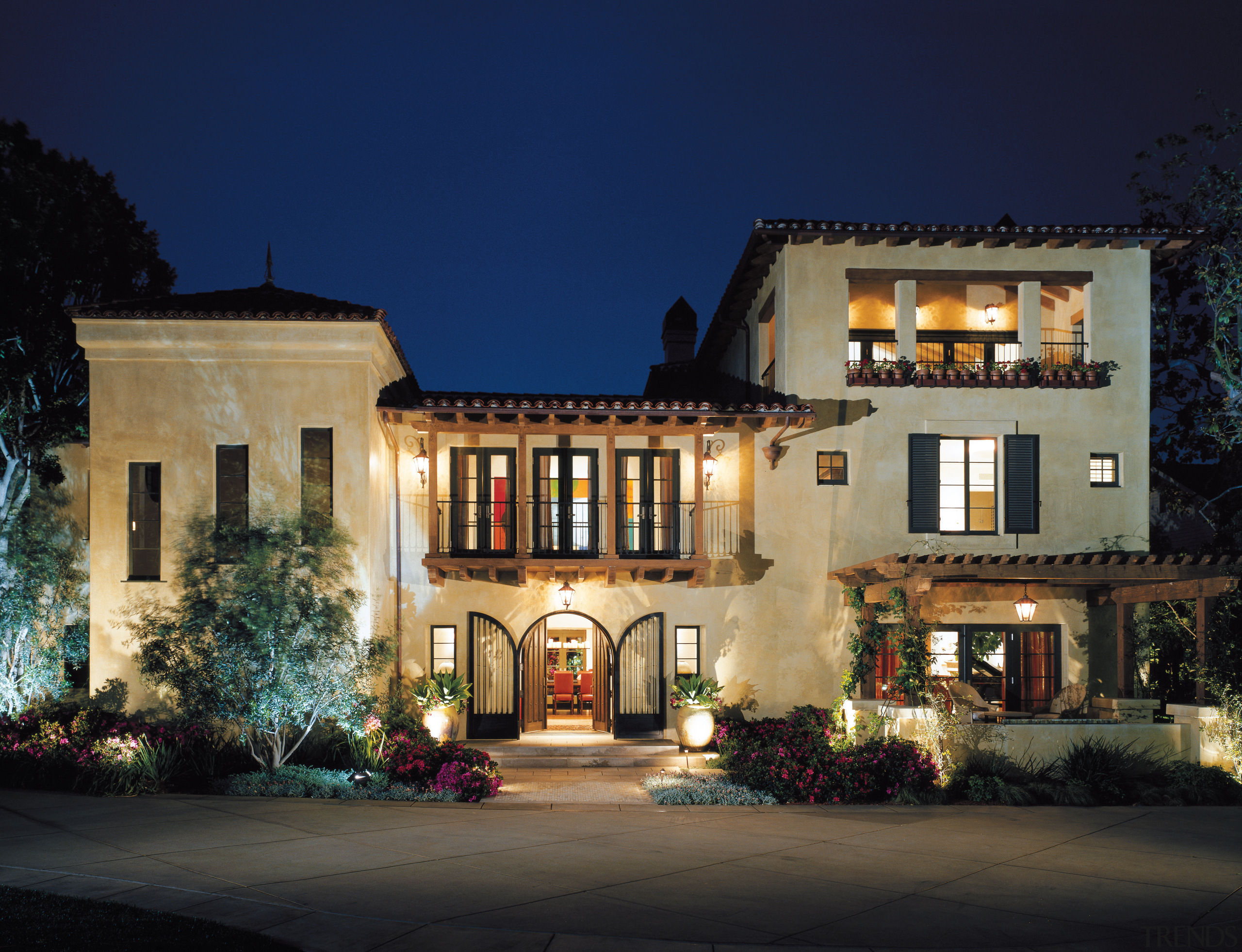 This spanish-style residence was transformed by the Landry building, estate, evening, facade, home, house, landscape lighting, lighting, mansion, mixed use, night, property, real estate, window, blue, black