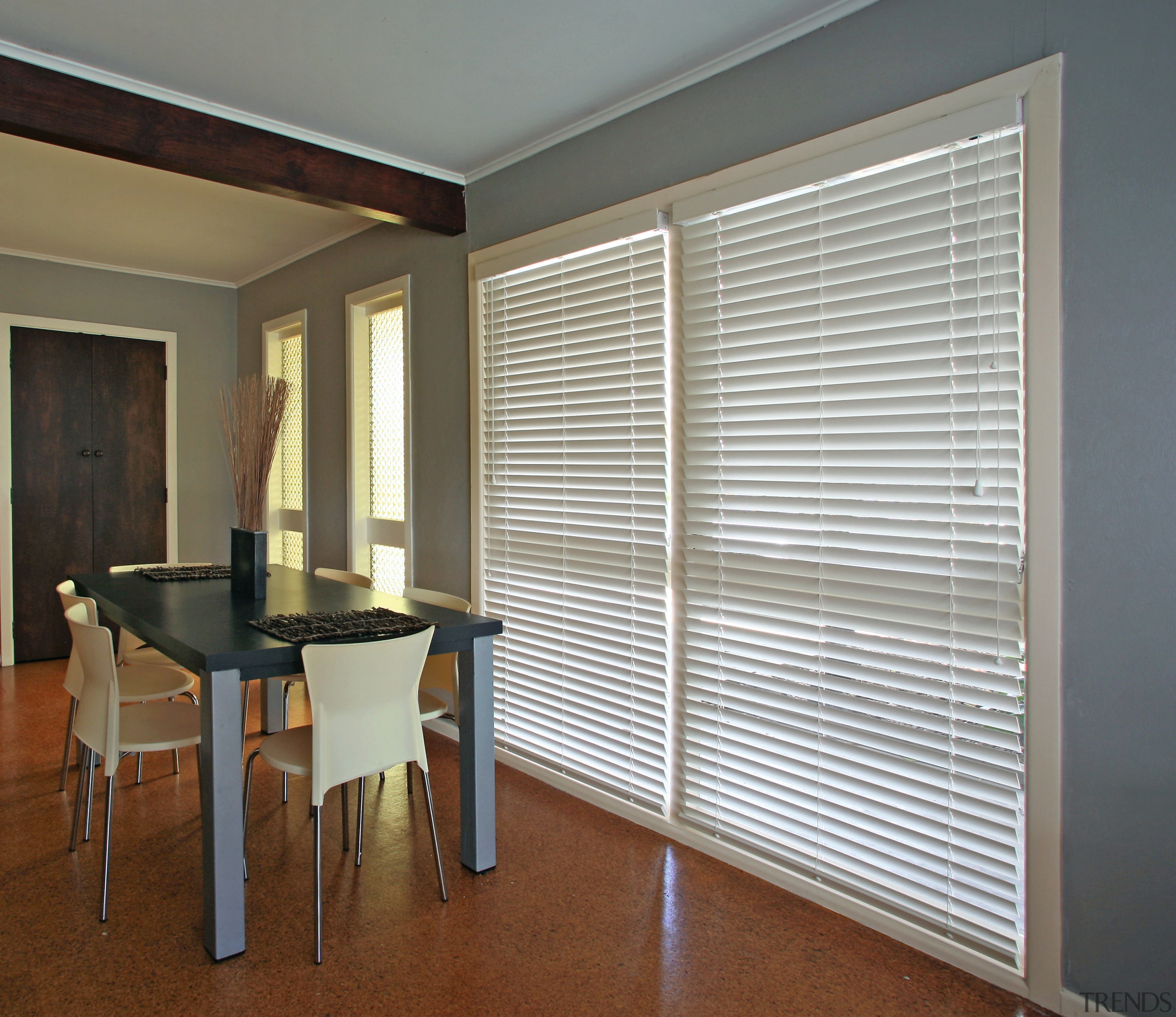 A view of this interior living space of door, floor, interior design, real estate, shade, window, window blind, window covering, window treatment, wood, gray, brown