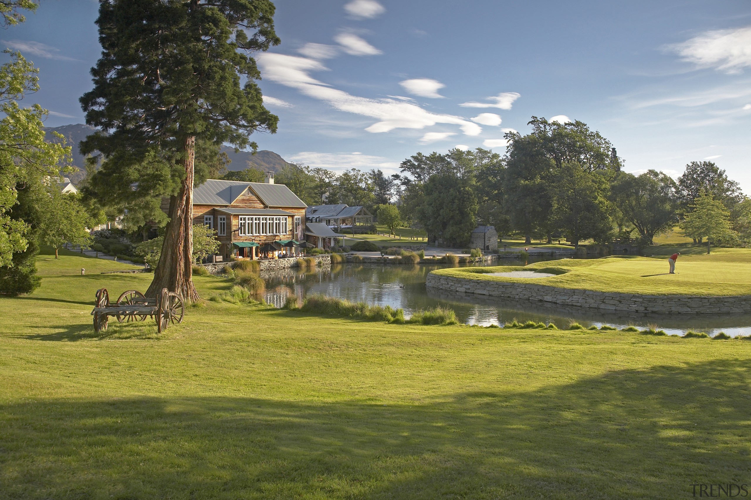 Here is a view of Millbrook Country Club cottage, estate, golf club, golf course, grass, home, lake, land lot, landscape, lawn, leisure, park, property, real estate, recreation, sky, tree, water, brown