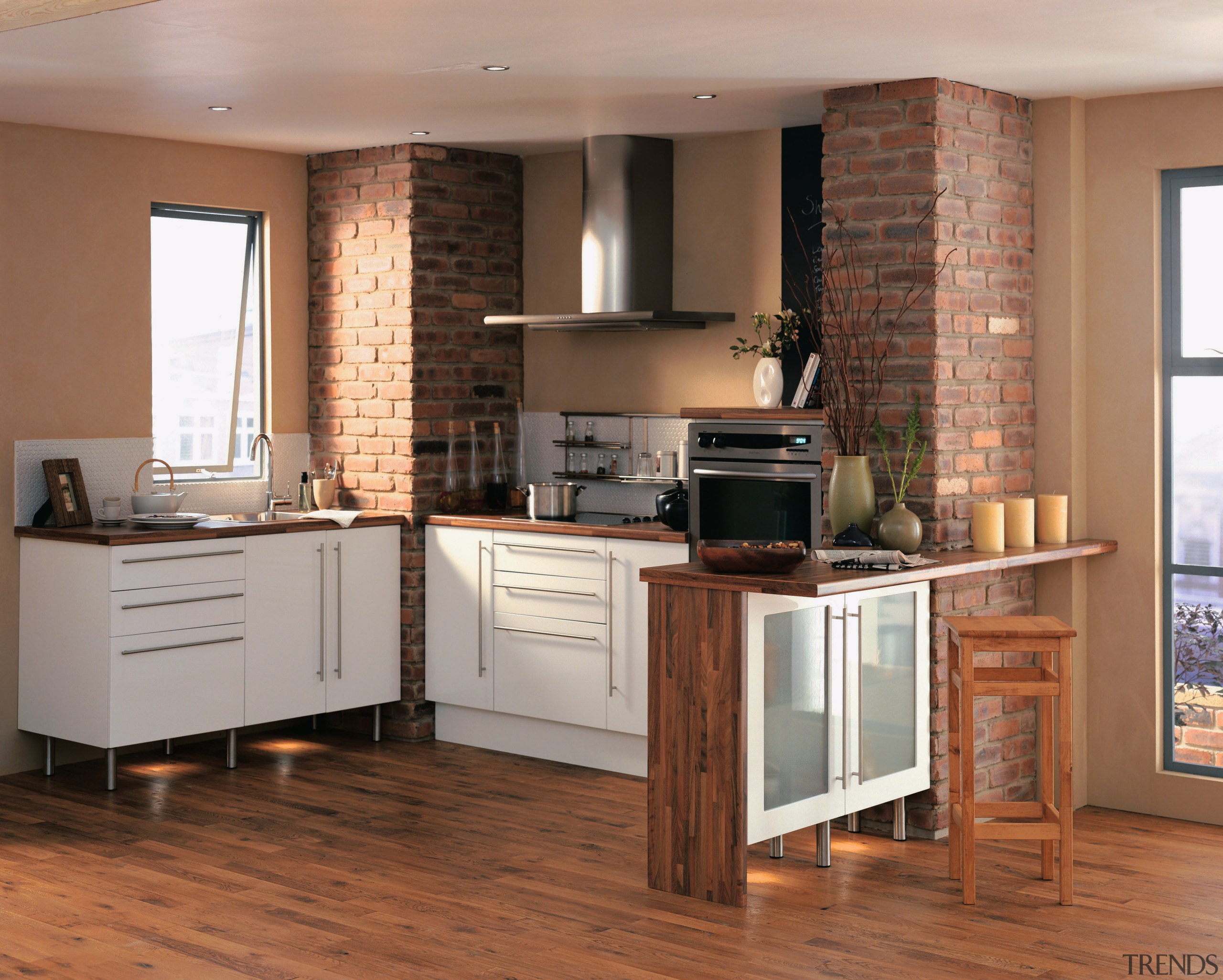 A view of a kitchen, brick and tan cabinetry, countertop, cuisine classique, floor, flooring, furniture, hardwood, interior design, kitchen, laminate flooring, room, wood, wood flooring, brown